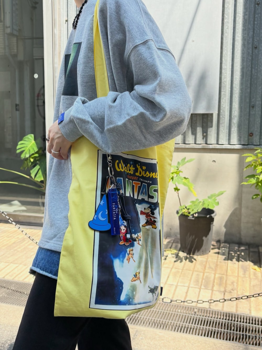 グレー系のスウェット、その他のトートバッグ、シルバー系のキーホルダーを着用したレディースの夏コーディネートの2枚目の写真