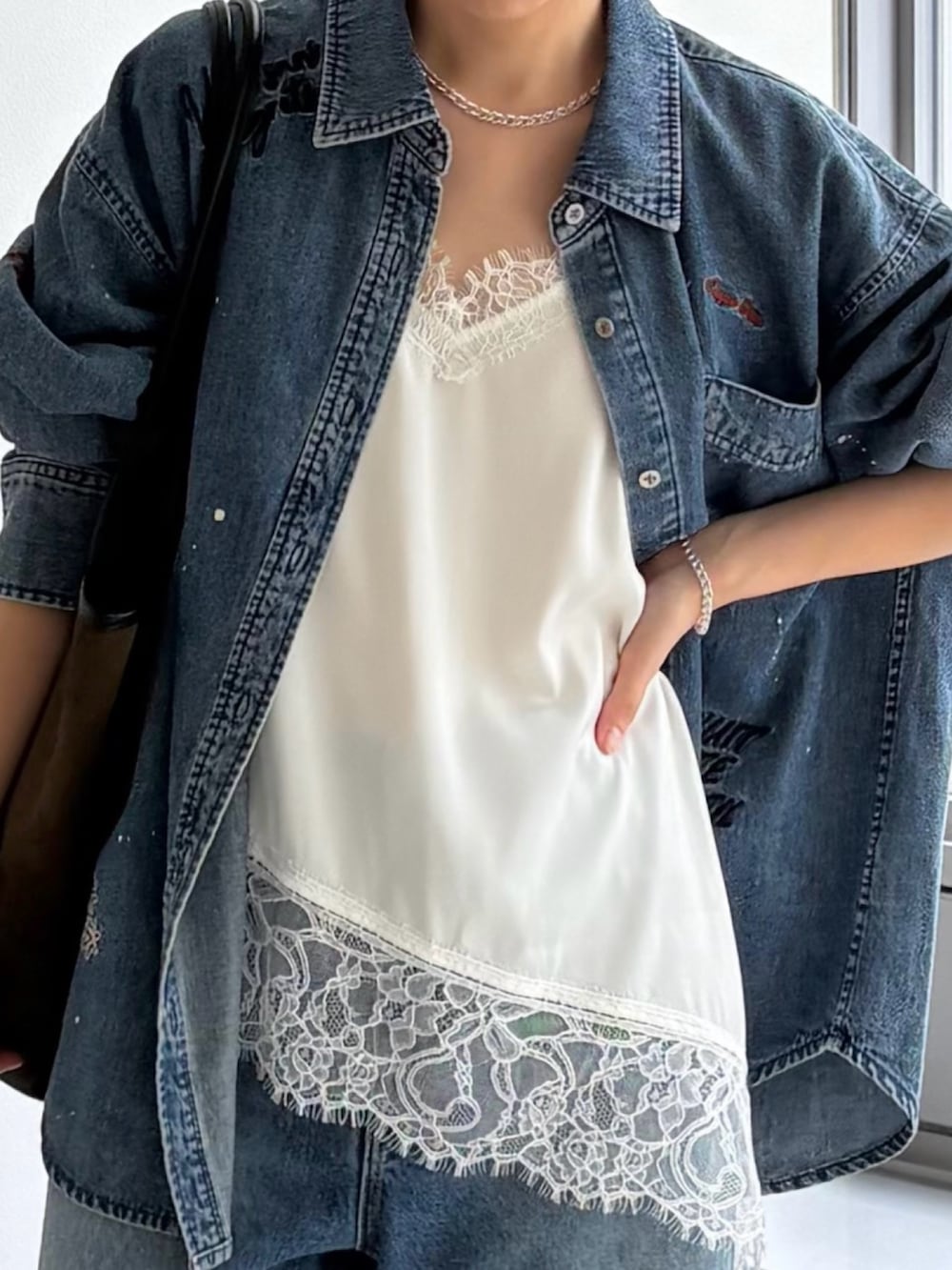 ブルー系のシャツ/ブラウス、ブルー系のデニムパンツ、ホワイト系のキャミソールを着用したレディースの夏コーディネートの3枚目の写真