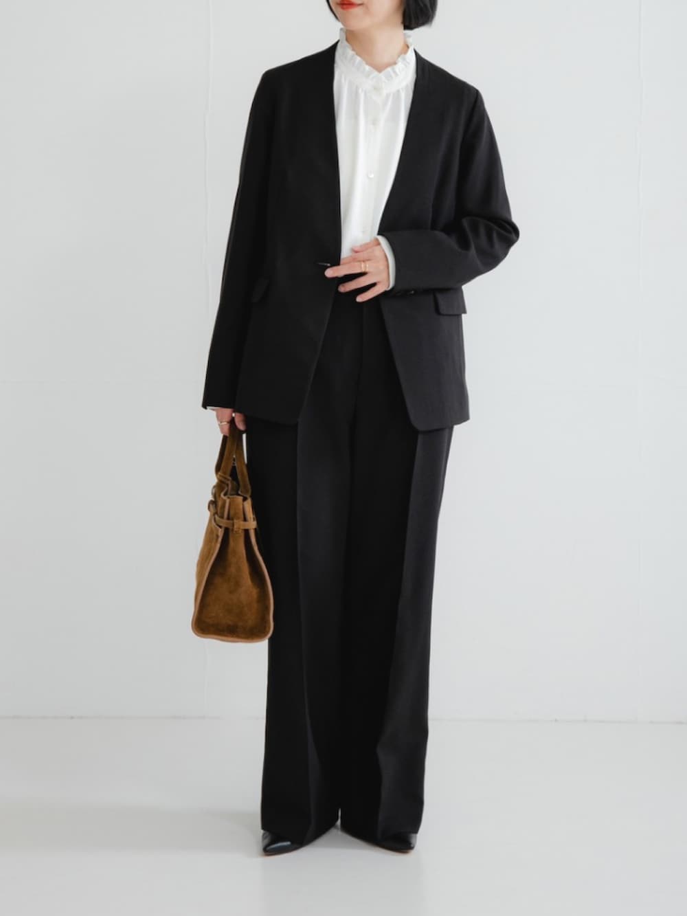 ブラック系のノーカラージャケット、ホワイト系のシャツ/ブラウス、ブラック系のその他パンツを着用したレディースの冬コーディネートの2枚目の写真