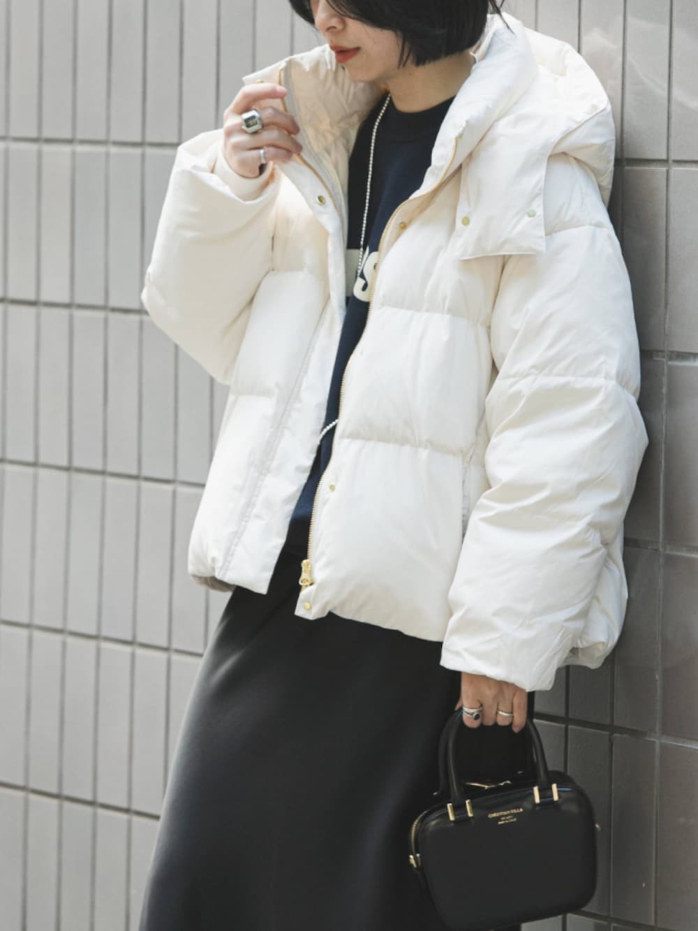 ブルー系のスウェット、ホワイト系のダウンジャケット/コート、ブラック系のスカートを着用したレディースの冬コーディネートの3枚目の写真