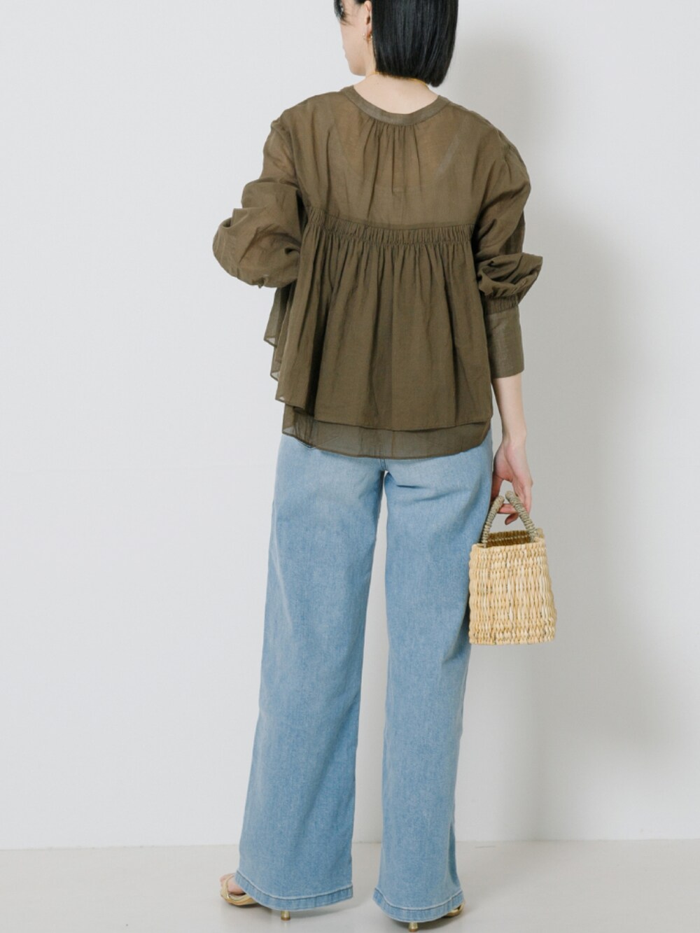 ベージュ系のシャツ/ブラウス、ブルー系のデニムパンツを着用したレディースの春コーディネートの2枚目の写真