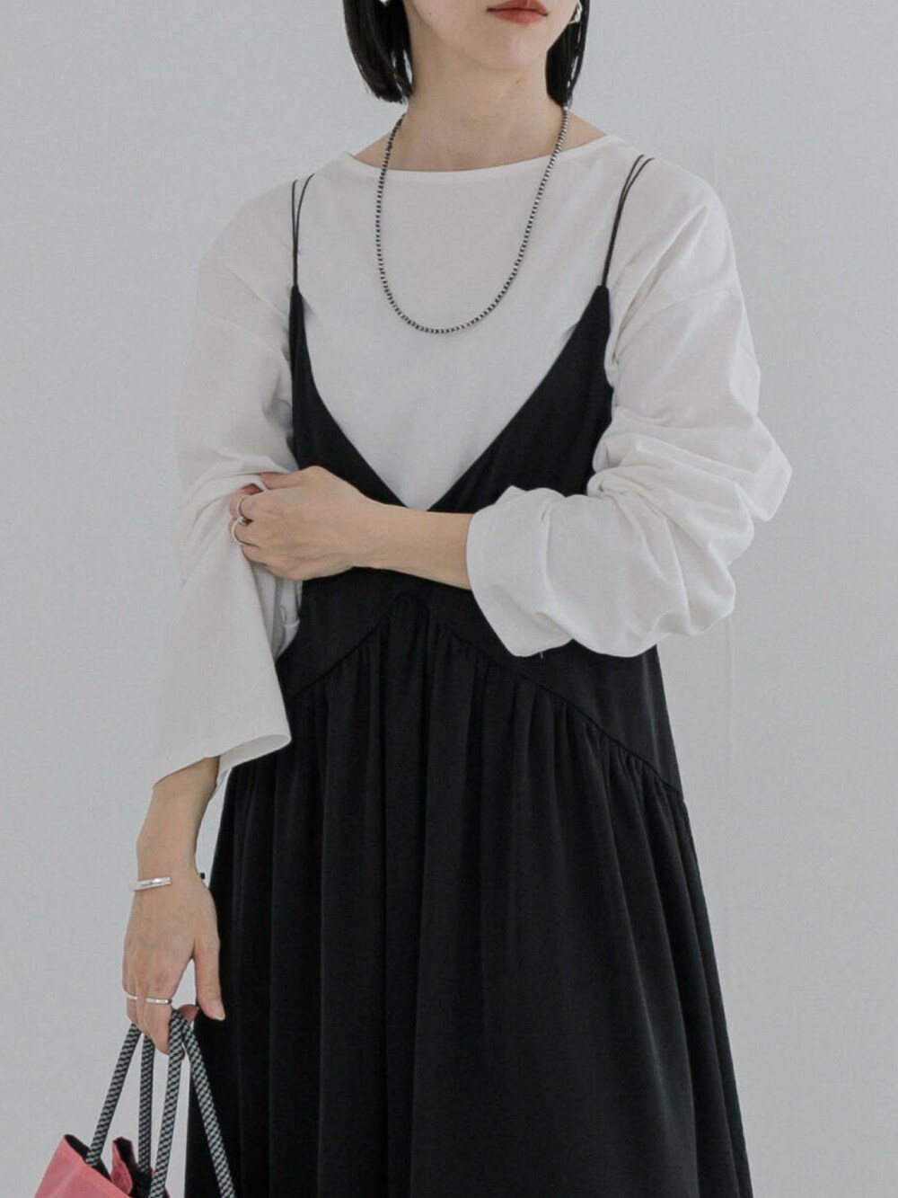 ホワイト系のTシャツ/カットソー、ブラック系のワンピース、ブラック系のブーツを着用したレディースの冬コーディネートの3枚目の写真