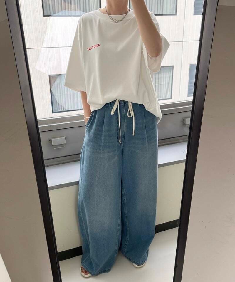 ブルー系のデニムパンツ、ホワイト系のTシャツ/カットソーを着用したレディースの夏コーディネートの5枚目の写真