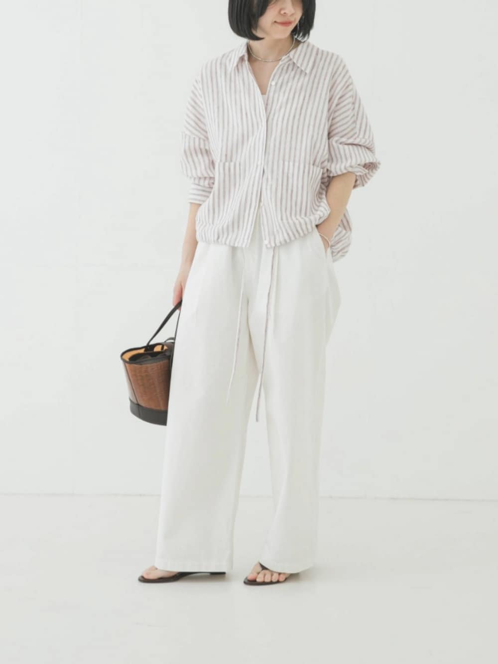 レッド系のシャツ/ブラウス、ブラウン系のかごバッグ、ホワイト系のその他パンツを着用したレディースの春コーディネートの2枚目の写真