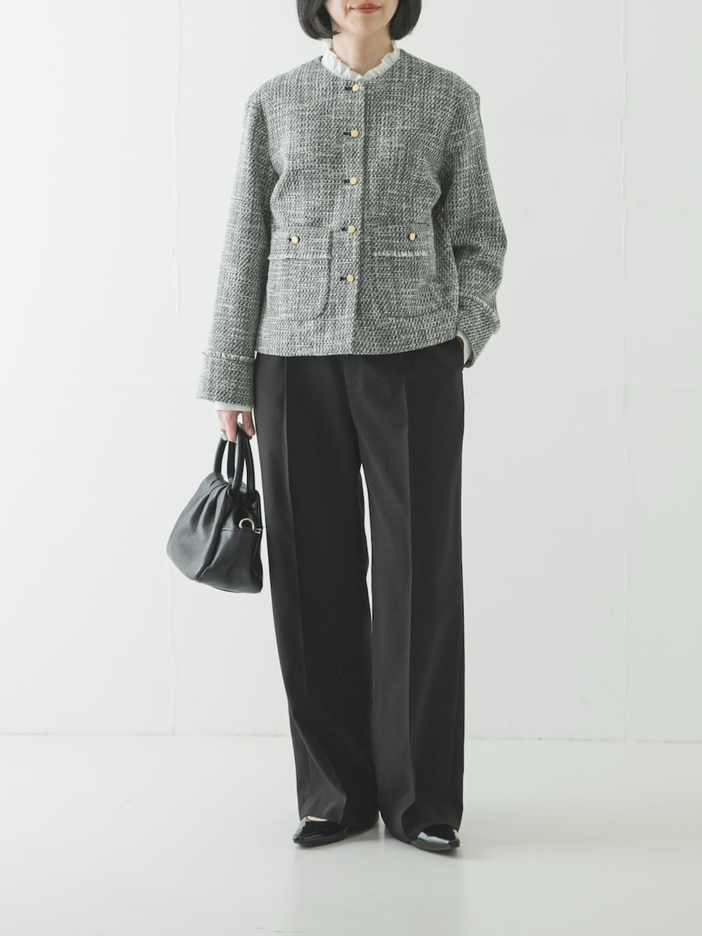 ブラック系のノーカラージャケット、ホワイト系のシャツ/ブラウス、ブラック系のその他パンツを着用したレディースの春コーディネートの2枚目の写真