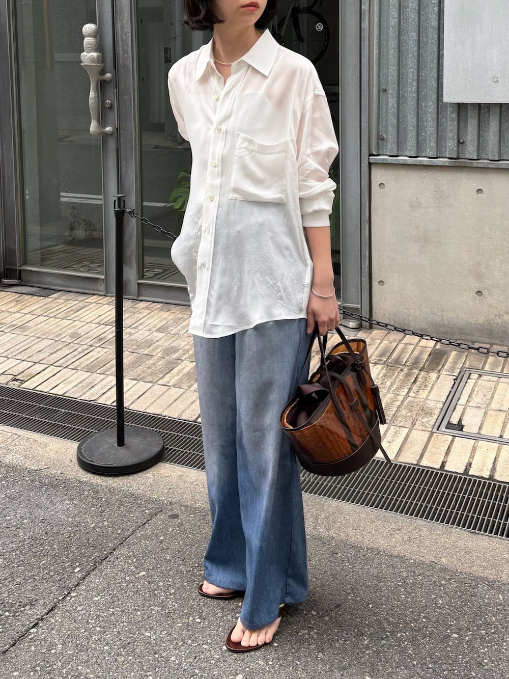 ブルー系のその他パンツ、ホワイト系のシャツ/ブラウス、シルバー系のネックレスを着用したレディースの春コーディネートの2枚目の写真