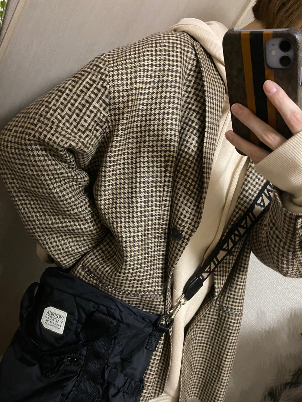 ブラック系のショルダーバッグ、その他のテーラードジャケット、ホワイト系のパーカーを着用したレディースの秋コーディネートの2枚目の写真