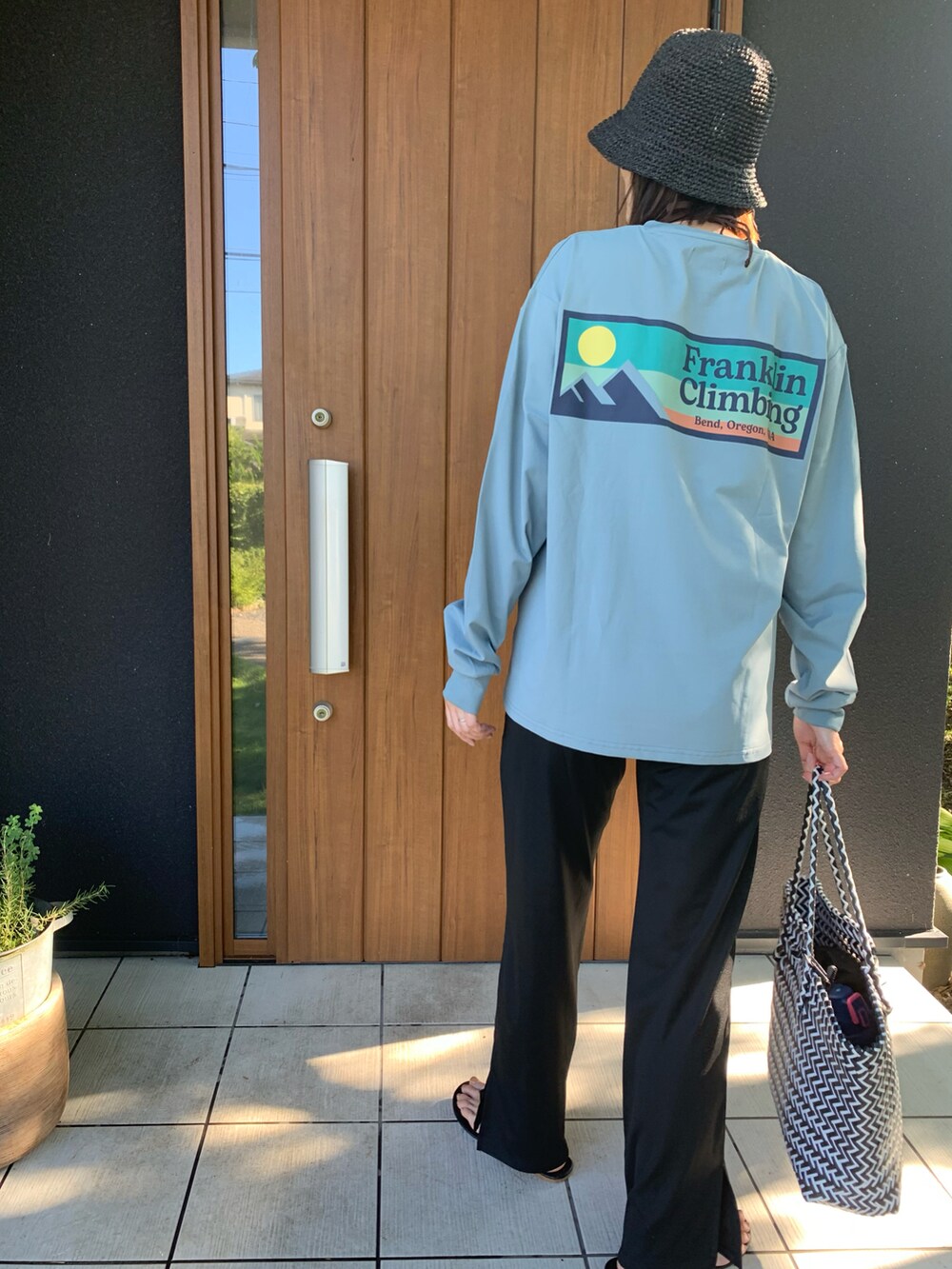 その他のかごバッグ、ブラック系のサンダル、ブラック系の帽子を着用したレディースの夏コーディネートの2枚目の写真