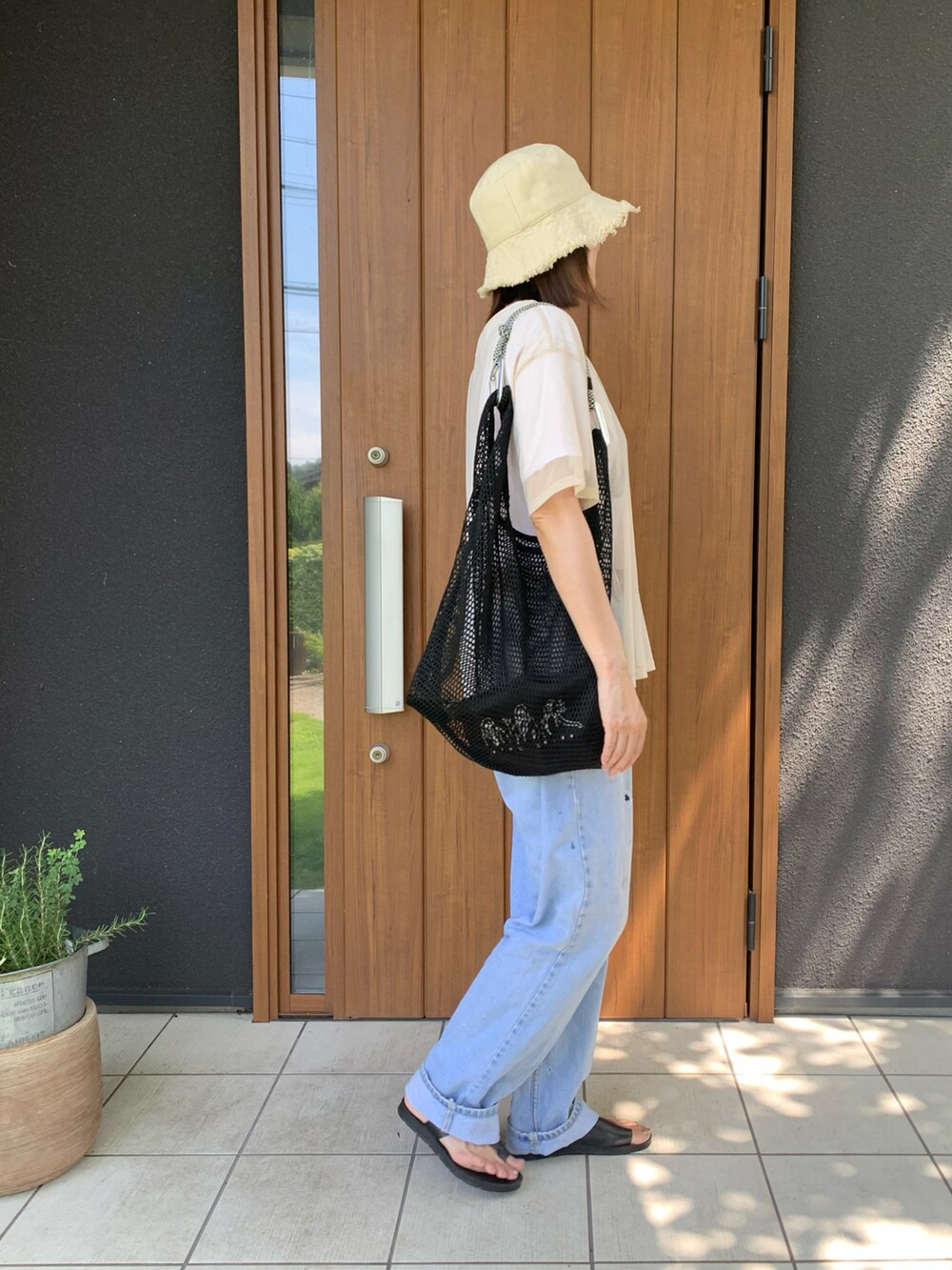 ベージュ系のTシャツ/カットソー、ブラック系のショルダーバッグ、ブラック系のサンダルを着用したレディースの夏コーディネートの2枚目の写真