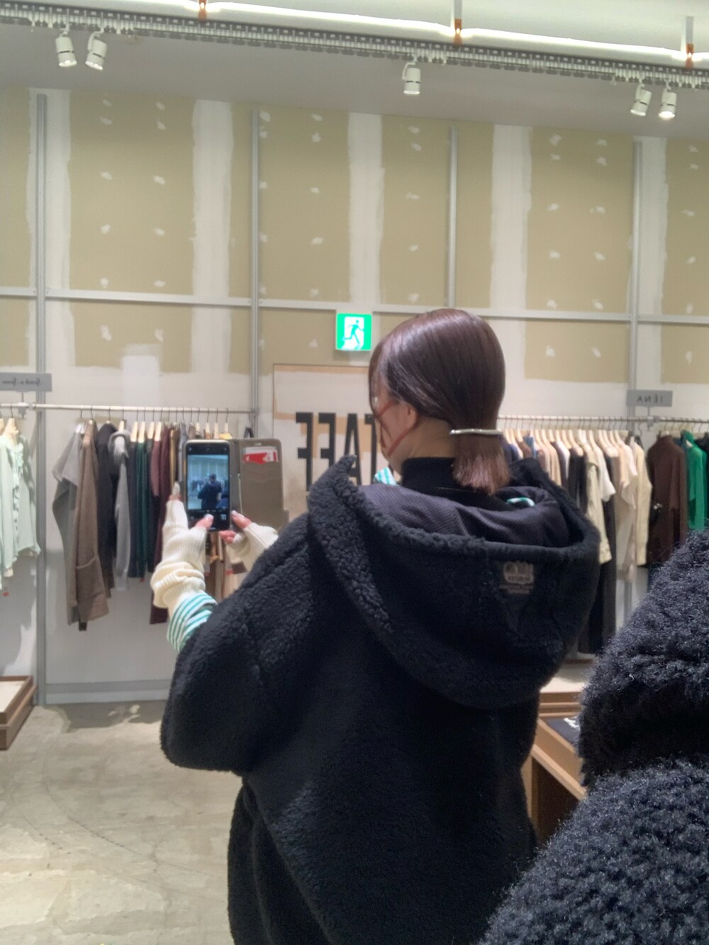 ブラック系のジャケット/アウター、ブラック系のサロペット/オーバーオール、グレー系のブーツを着用したレディースの冬コーディネートの2枚目の写真