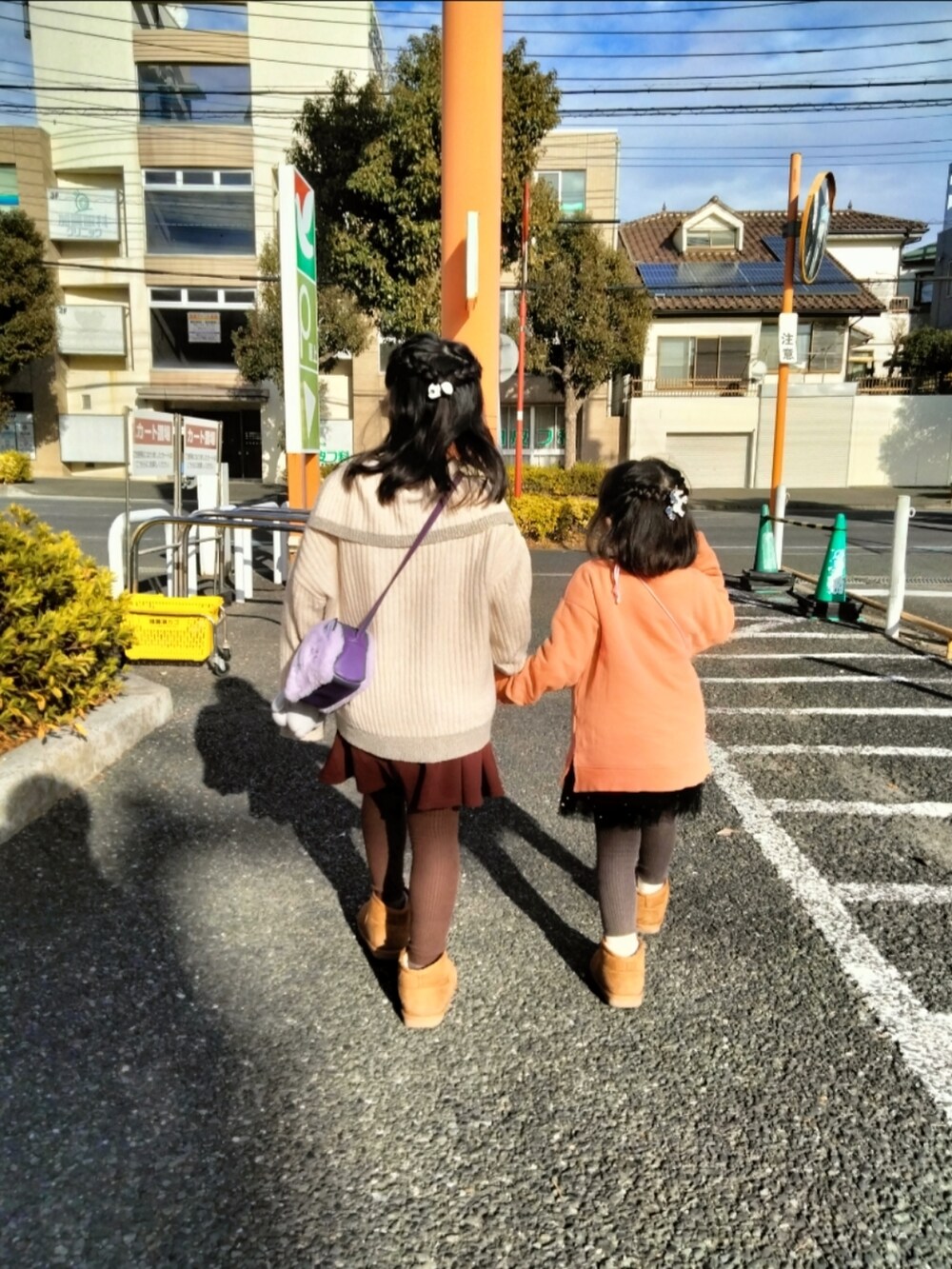 オレンジ系のブルゾン、ホワイト系のニット/セーター、レッド系のスカートを着用したキッズの冬コーディネートの2枚目の写真