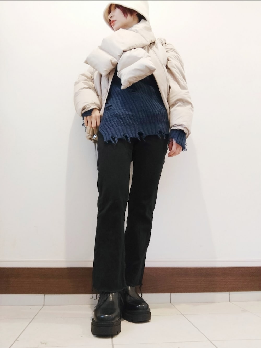 ベージュ系のダウンジャケット/コート、ブルー系のニット/セーター、ブラック系のデニムパンツを着用したレディースの冬コーディネートの2枚目の写真