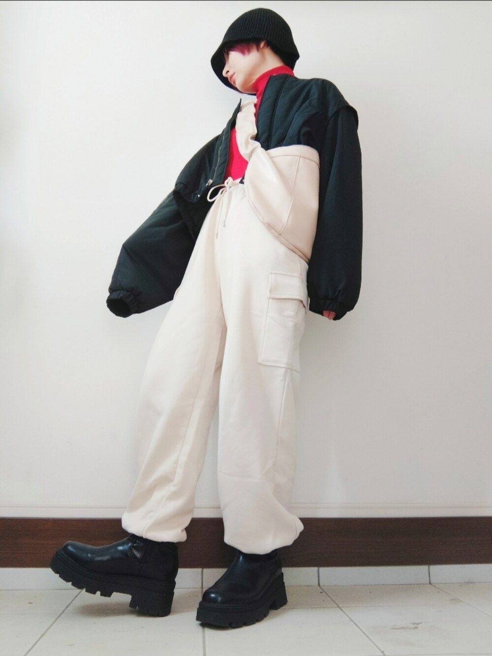 ブラック系のノーカラージャケット、レッド系のニット/セーター、ホワイト系のショルダーバッグを着用したレディースの冬コーディネートの2枚目の写真