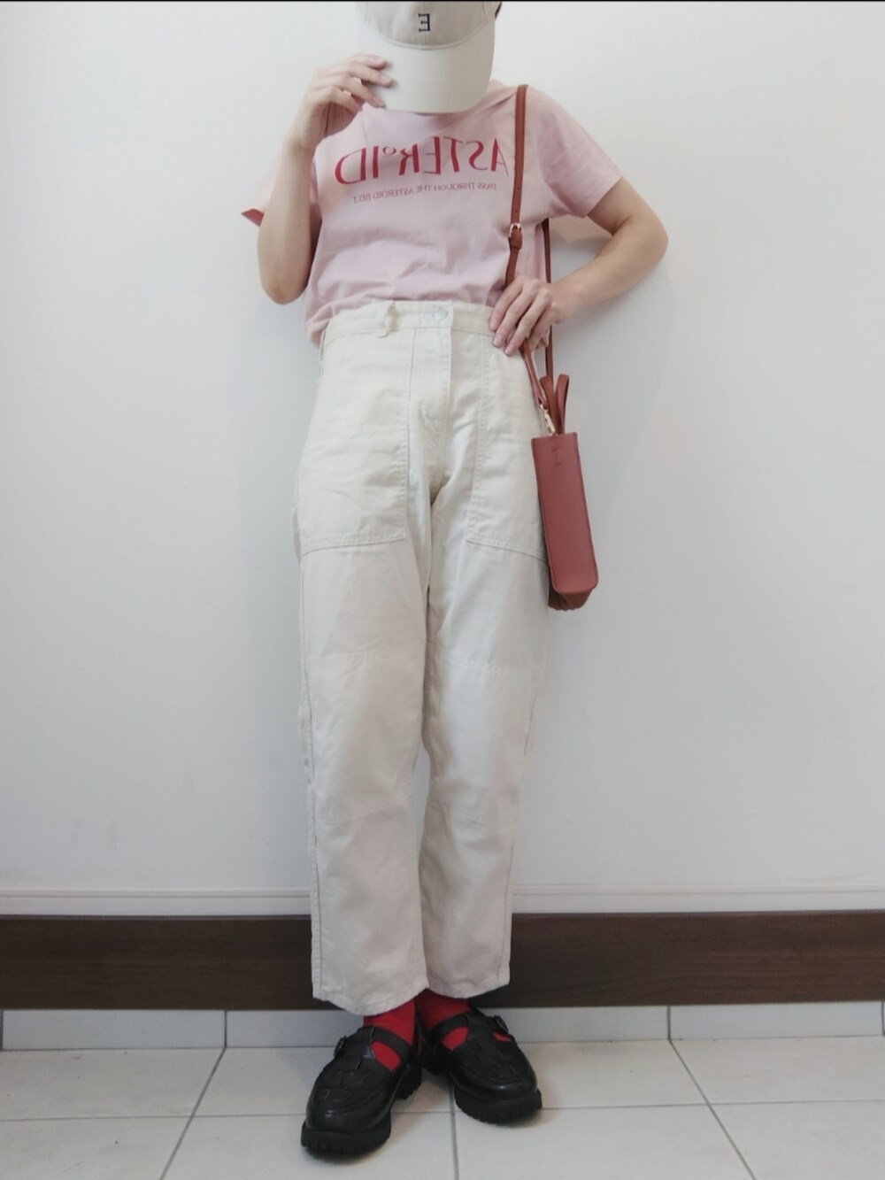 ピンク系のTシャツ/カットソー、ベージュ系のトートバッグ、ホワイト系のデニムパンツを着用したレディースの夏コーディネートの2枚目の写真