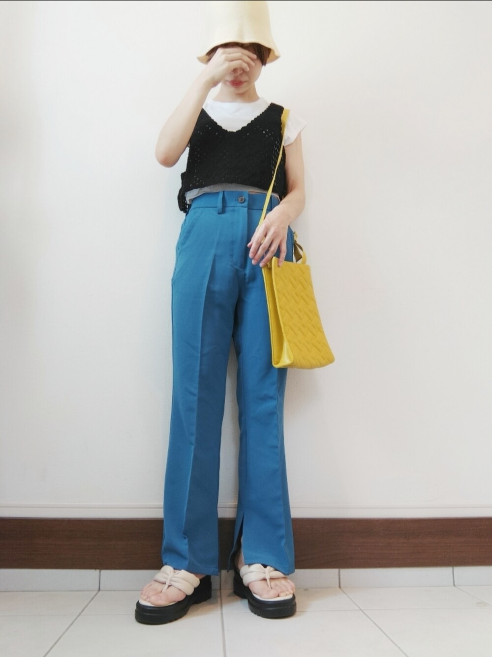 ブラック系のベスト、ホワイト系のTシャツ/カットソー、イエロー系のショルダーバッグを着用したレディースの夏コーディネートの2枚目の写真