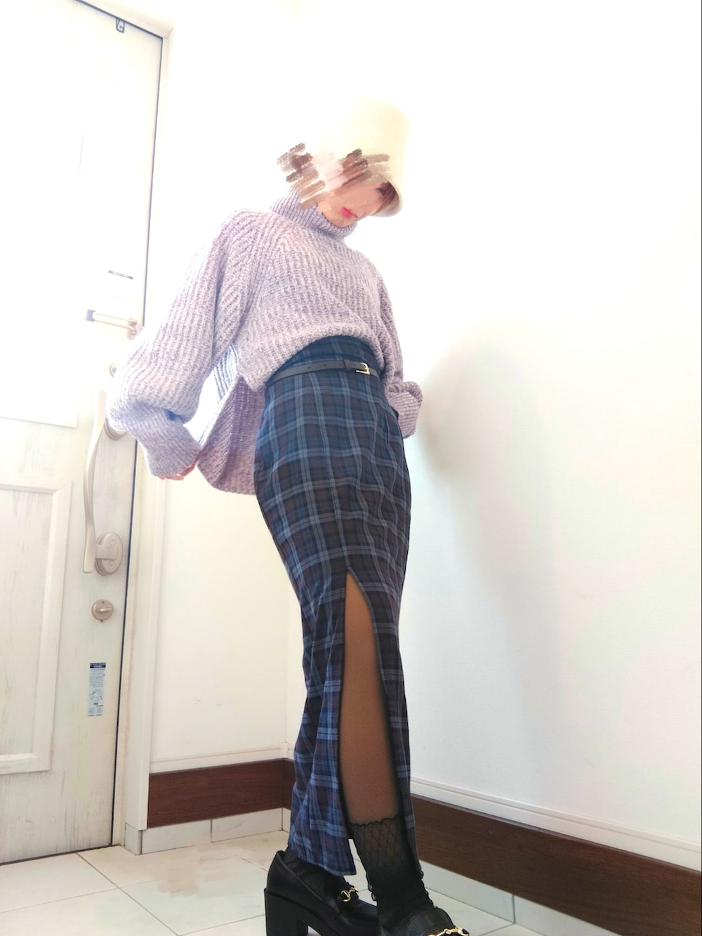 ブルー系のスカート、パープル系のニット/セーター、ブラック系のローファーを着用したレディースの冬コーディネートの2枚目の写真