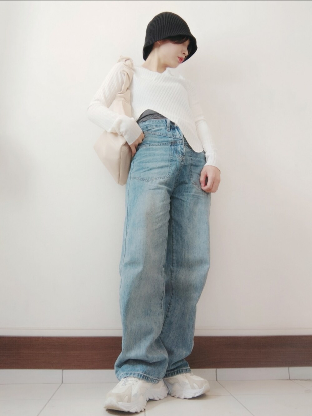 ホワイト系のTシャツ/カットソー、ホワイト系のショルダーバッグ、ブルー系のデニムパンツを着用したレディースの秋コーディネートの2枚目の写真