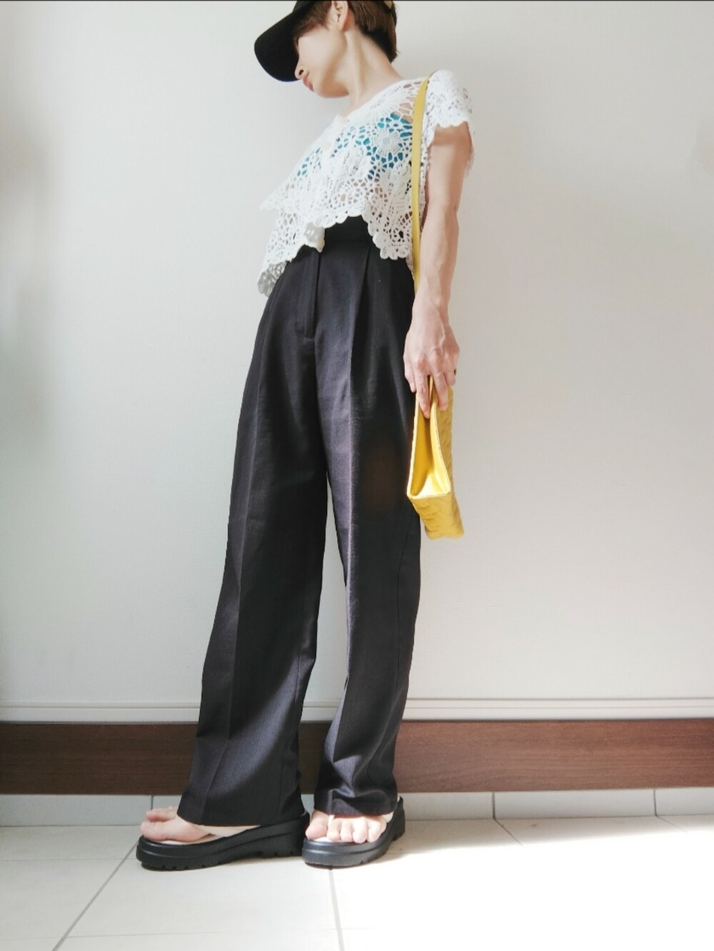 ホワイト系のカーディガン/ボレロ、イエロー系のショルダーバッグ、ブラック系のスラックスを着用したレディースの夏コーディネートの2枚目の写真