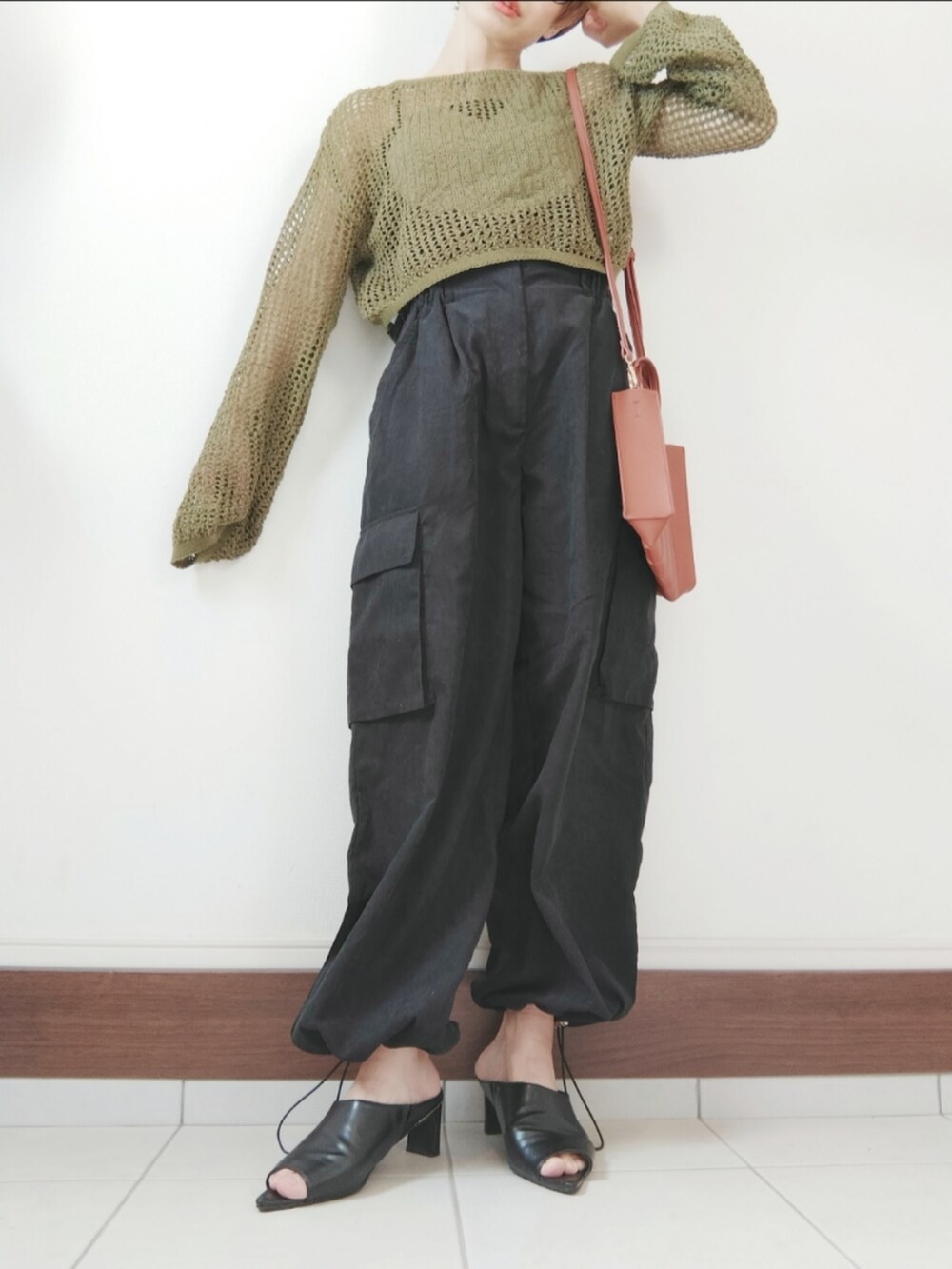 ブラック系のカーゴパンツ、ブラック系のサンダル、ベージュ系のトートバッグを着用したレディースの秋コーディネートの2枚目の写真