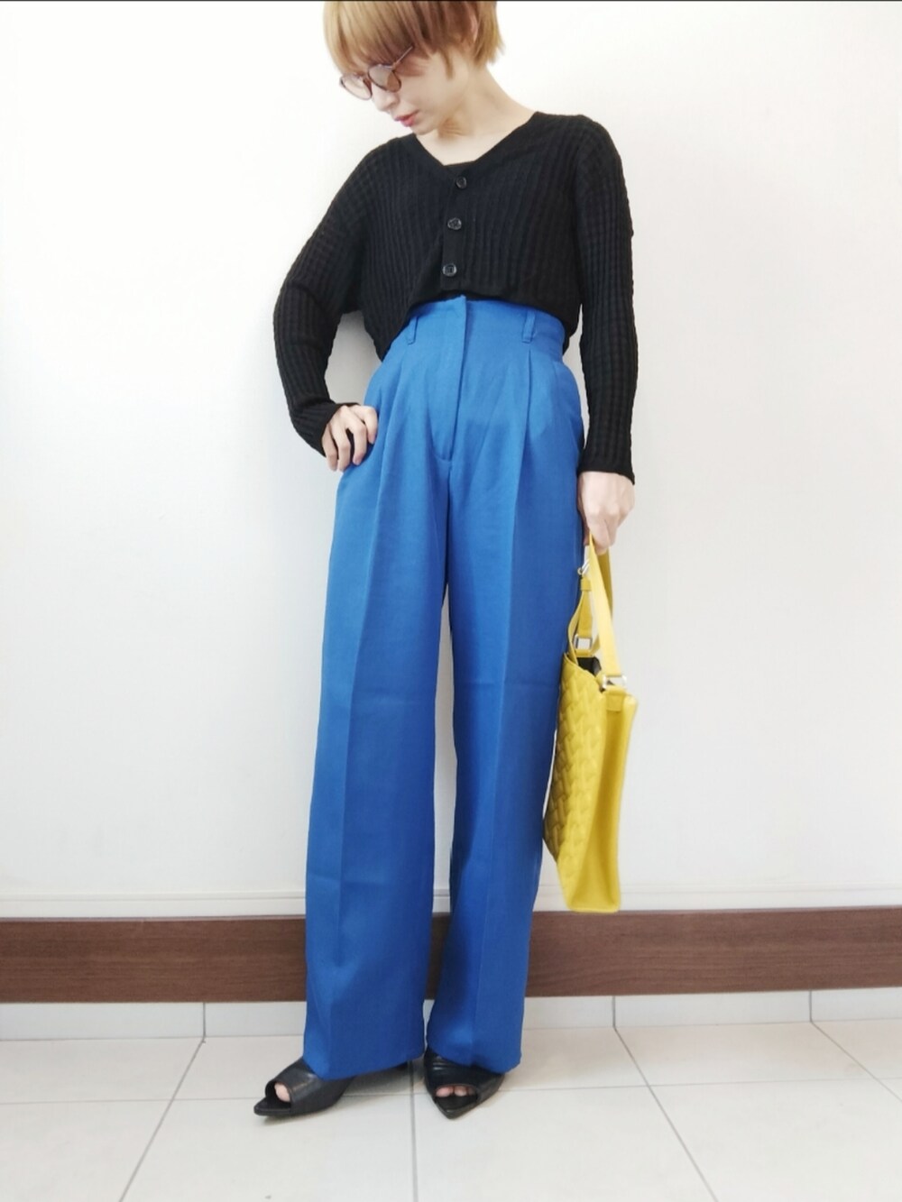 イエロー系のショルダーバッグ、ブラック系のタンクトップ、ブルー系のスラックスを着用したレディースの夏コーディネートの2枚目の写真