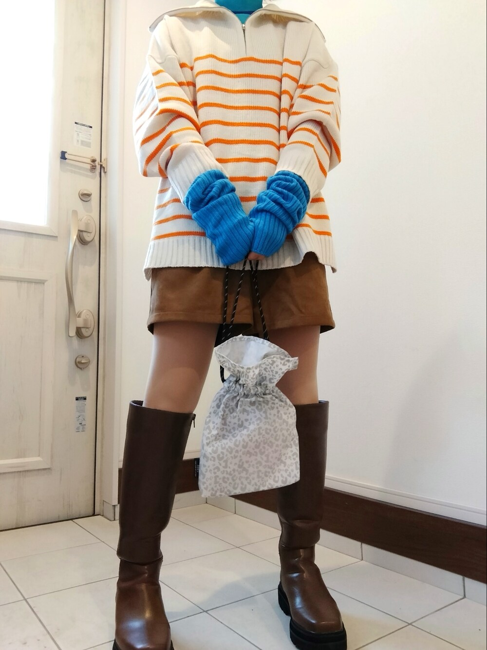 オレンジ系のニット/セーター、ブルー系のTシャツ/カットソー、イエロー系のその他パンツを着用したレディースの冬コーディネートの2枚目の写真