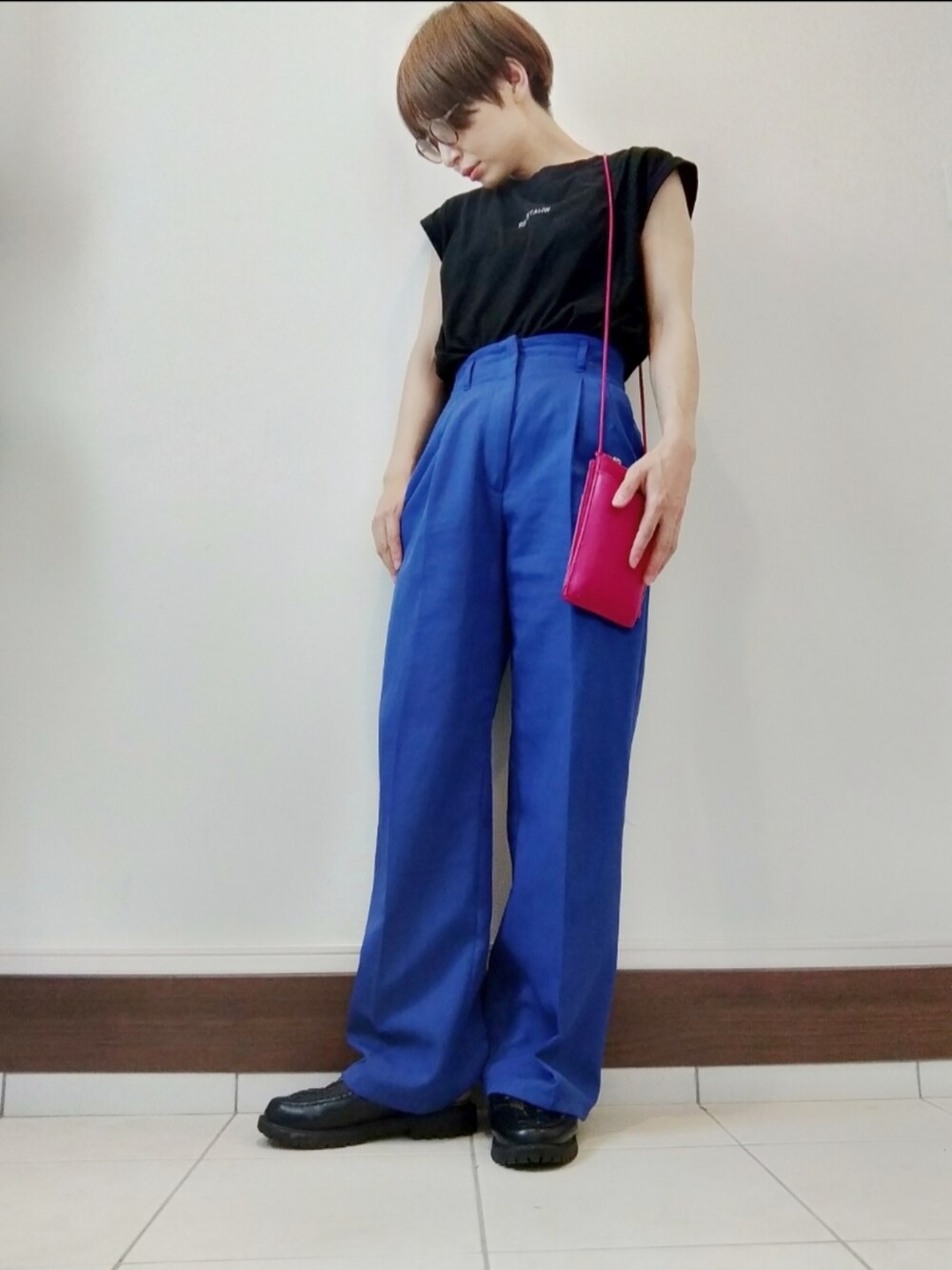 ブルー系のスラックス、ピンク系のショルダーバッグ、ブラック系のTシャツ/カットソーを着用したレディースの夏コーディネートの2枚目の写真