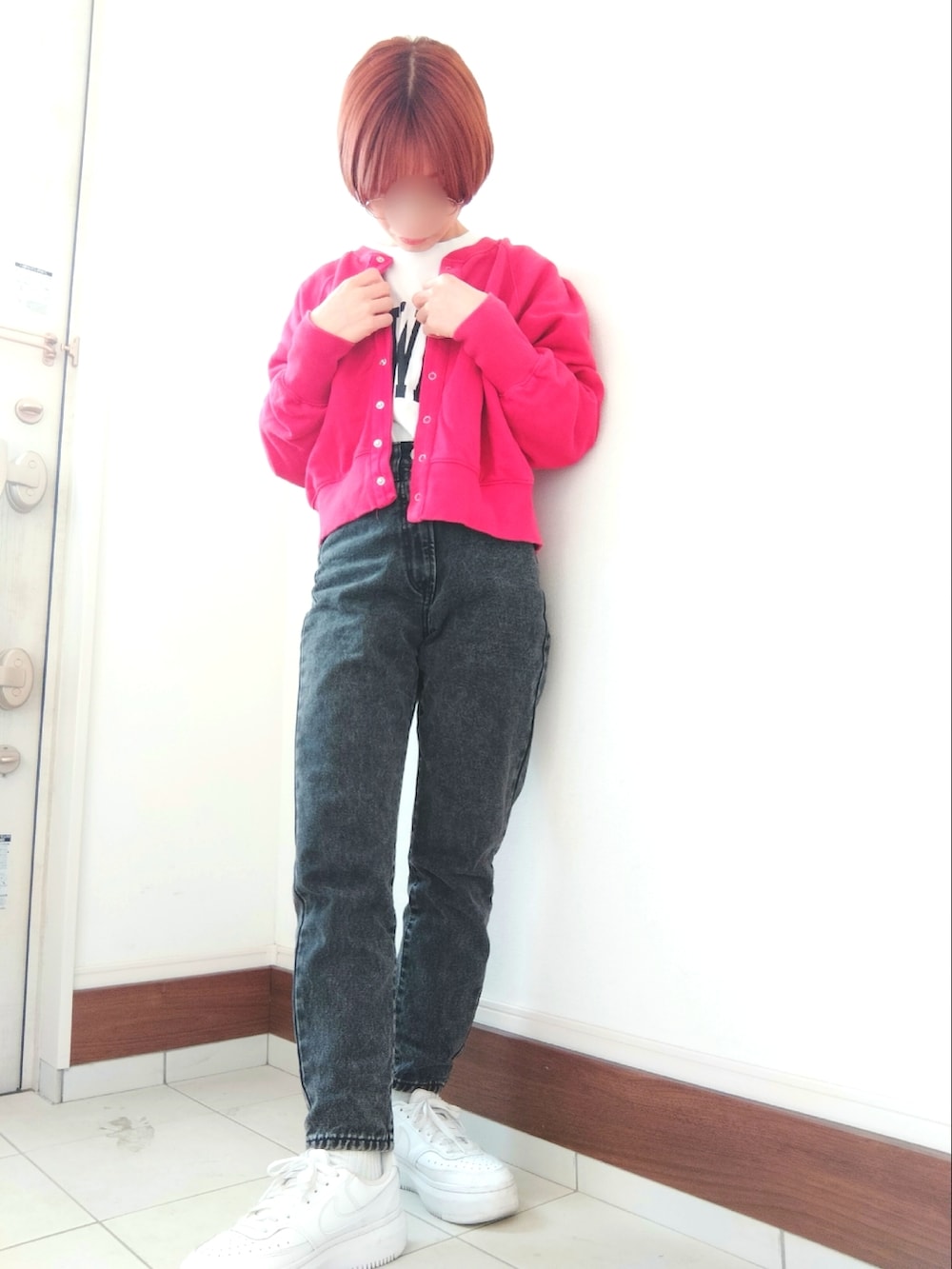 レッド系のカーディガン/ボレロ、ブラック系のデニムパンツ、ホワイト系のスニーカーを着用したレディースの冬コーディネートの2枚目の写真