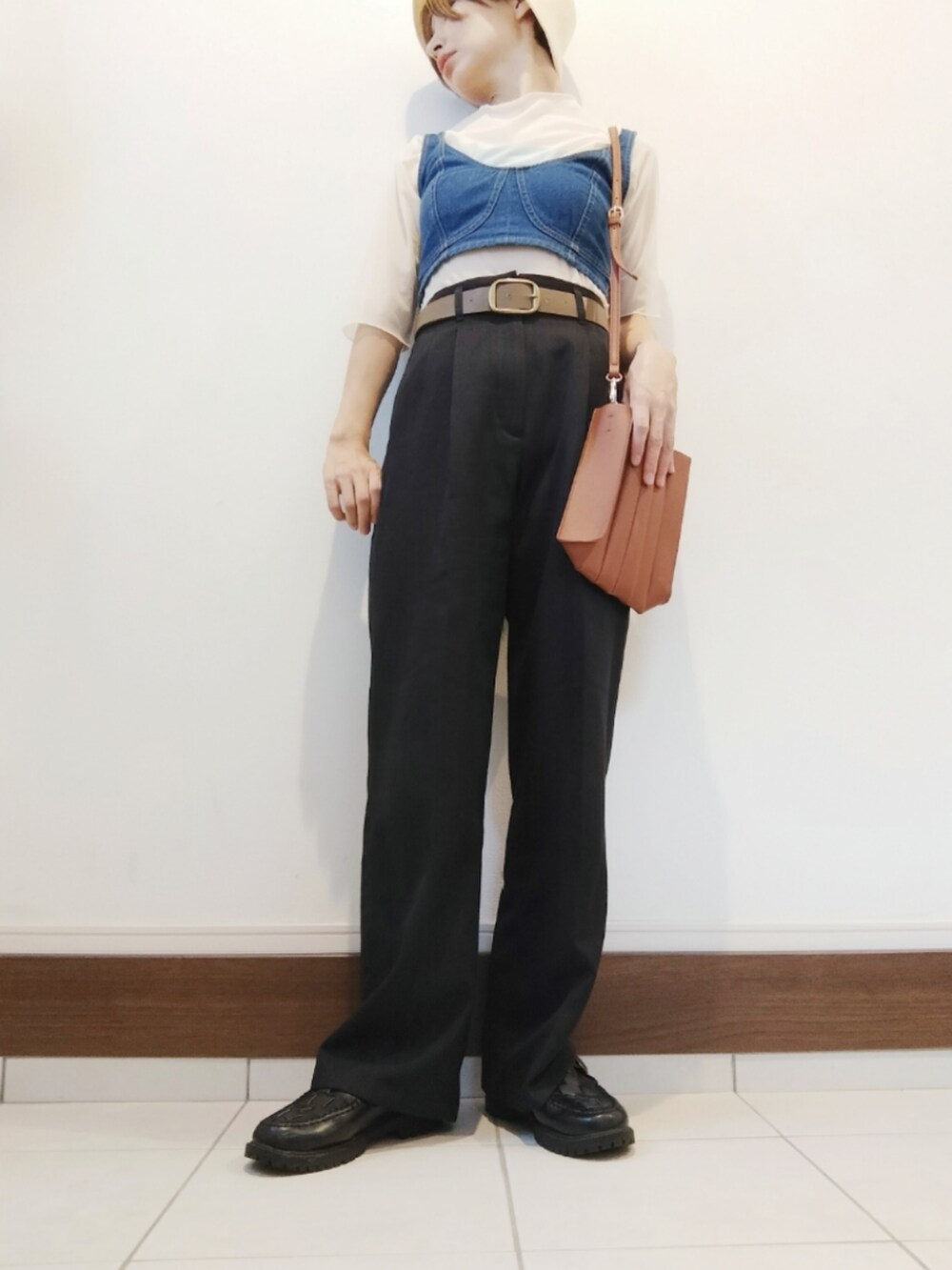 ブルー系のベスト、ベージュ系のトートバッグ、ブラック系のスラックスを着用したレディースの夏コーディネートの2枚目の写真