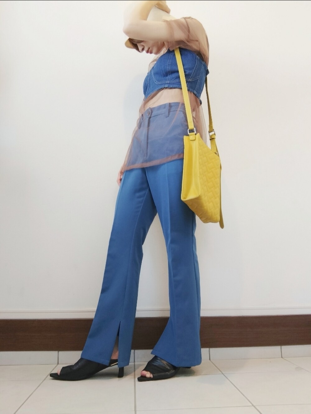 ブルー系のベスト、ブラウン系のTシャツ/カットソー、ブルー系のスラックスを着用したレディースの秋コーディネートの2枚目の写真