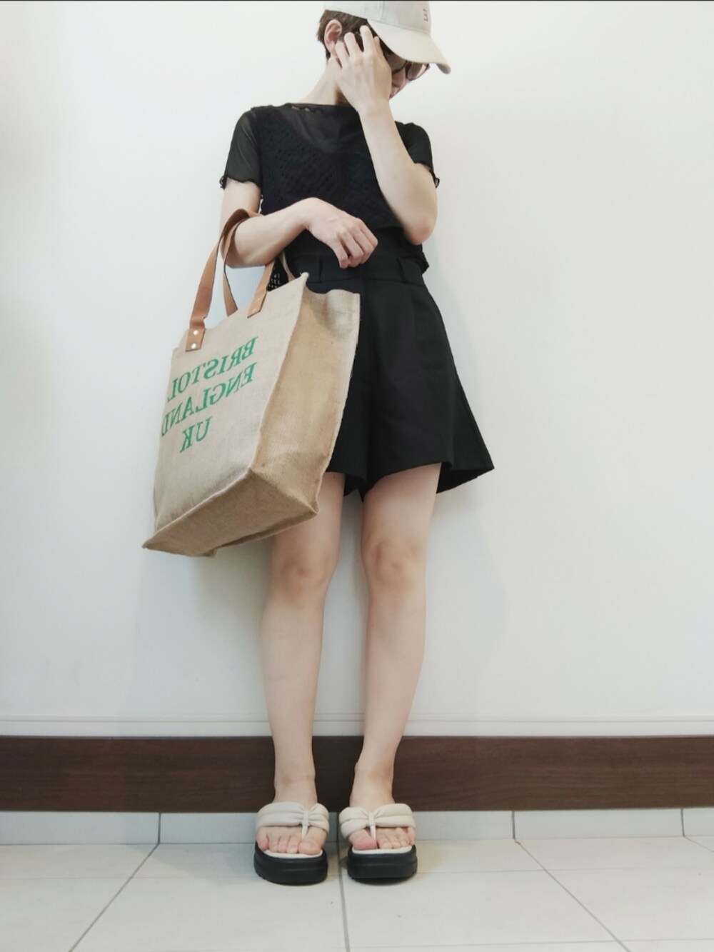 ブラック系のベスト、ブラック系のその他パンツ、グリーン系のトートバッグを着用したレディースの夏コーディネートの2枚目の写真