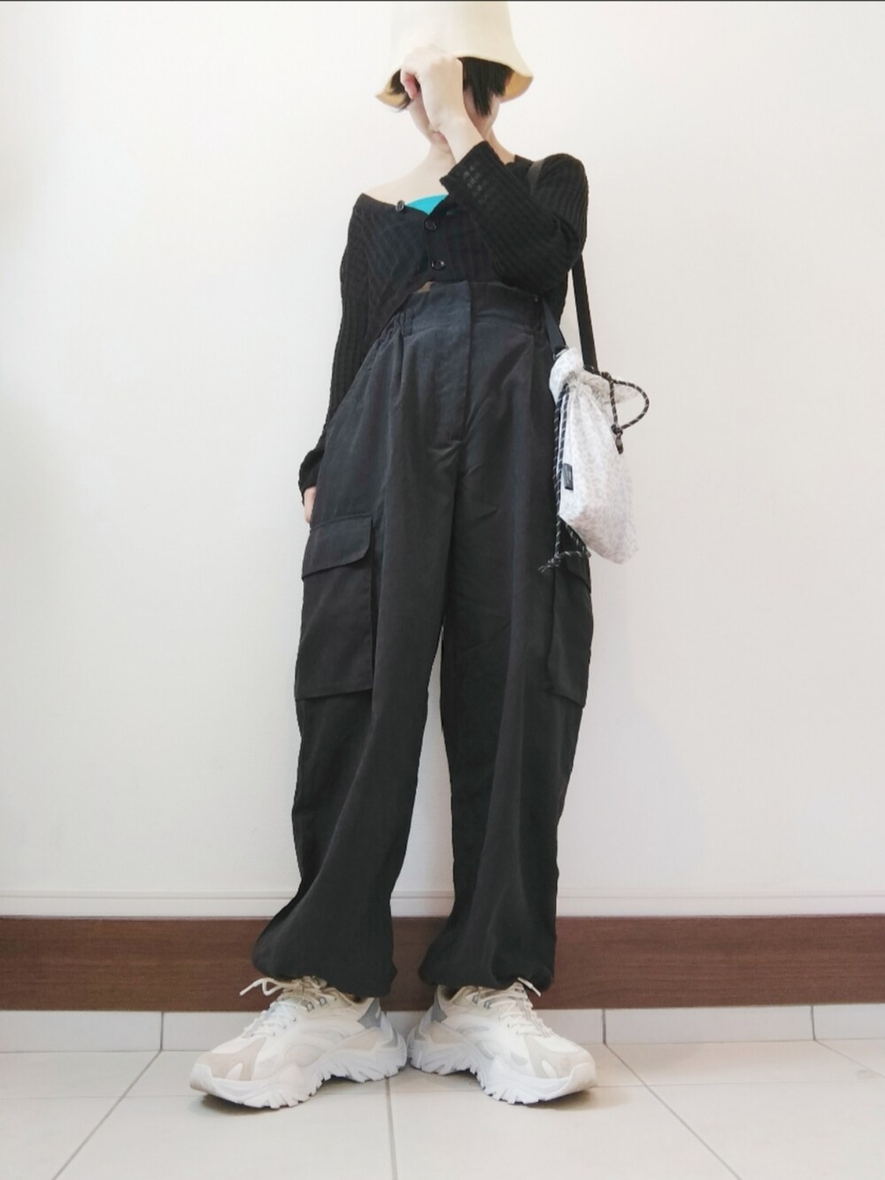 ブラック系のカーゴパンツ、ホワイト系のスニーカーを着用したレディースの秋コーディネートの2枚目の写真