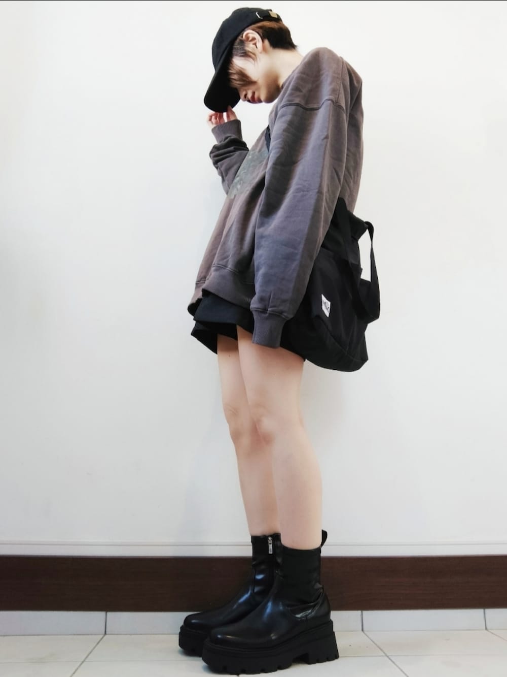 ブラウン系のスウェット、グレー系のスラックス、ブラック系のショルダーバッグを着用したレディースの秋コーディネートの2枚目の写真