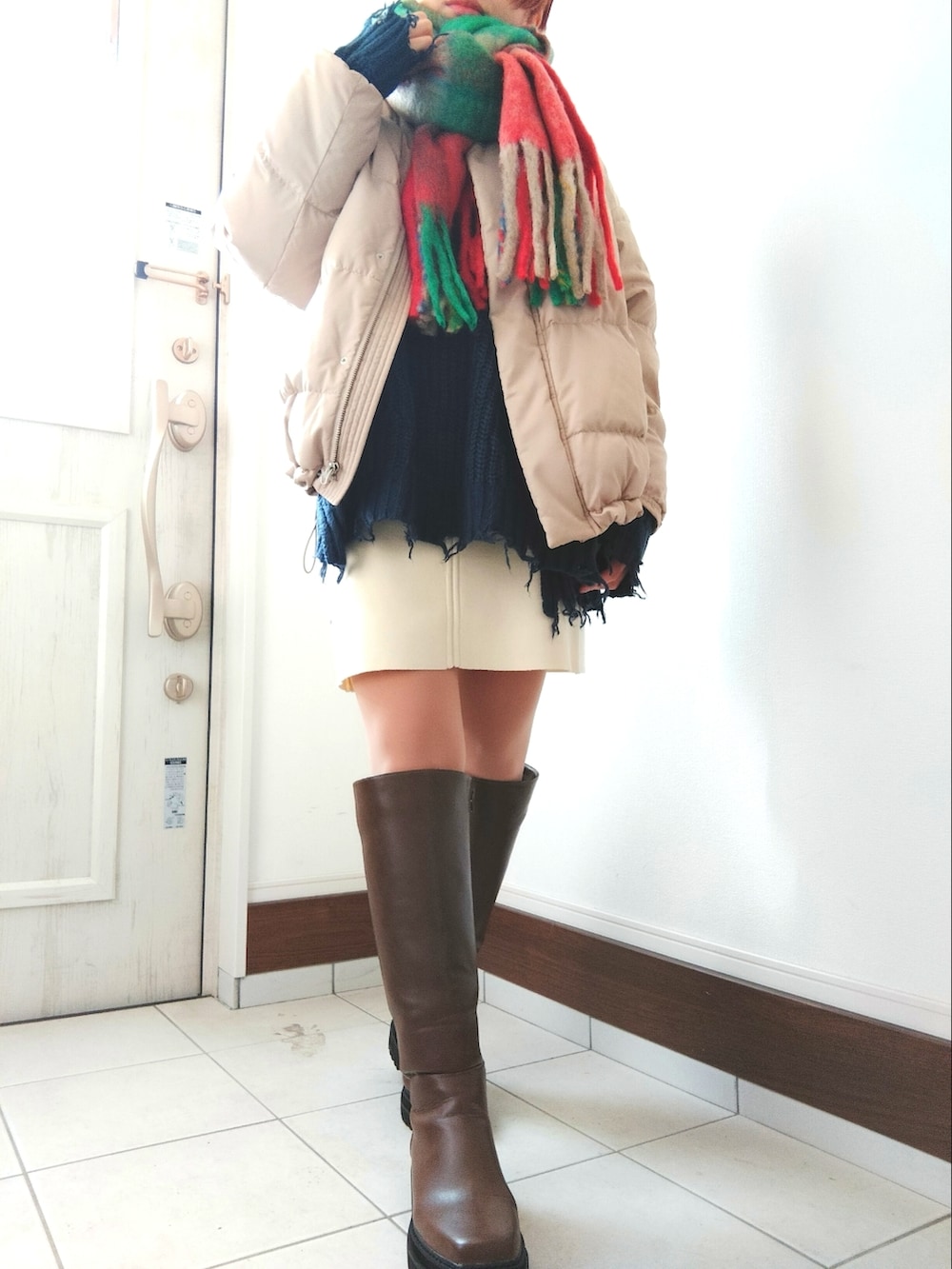 ブラウン系のブーツ、ベージュ系のダウンジャケット/コート、ブルー系のニット/セーターを着用したレディースの冬コーディネートの2枚目の写真