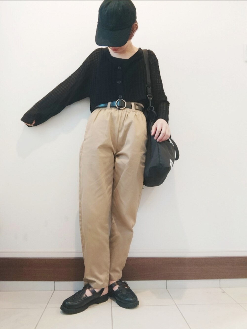 ブラック系のタンクトップ、ベージュ系のチノパンツ、ブラック系のサンダルを着用したレディースの春コーディネートの2枚目の写真