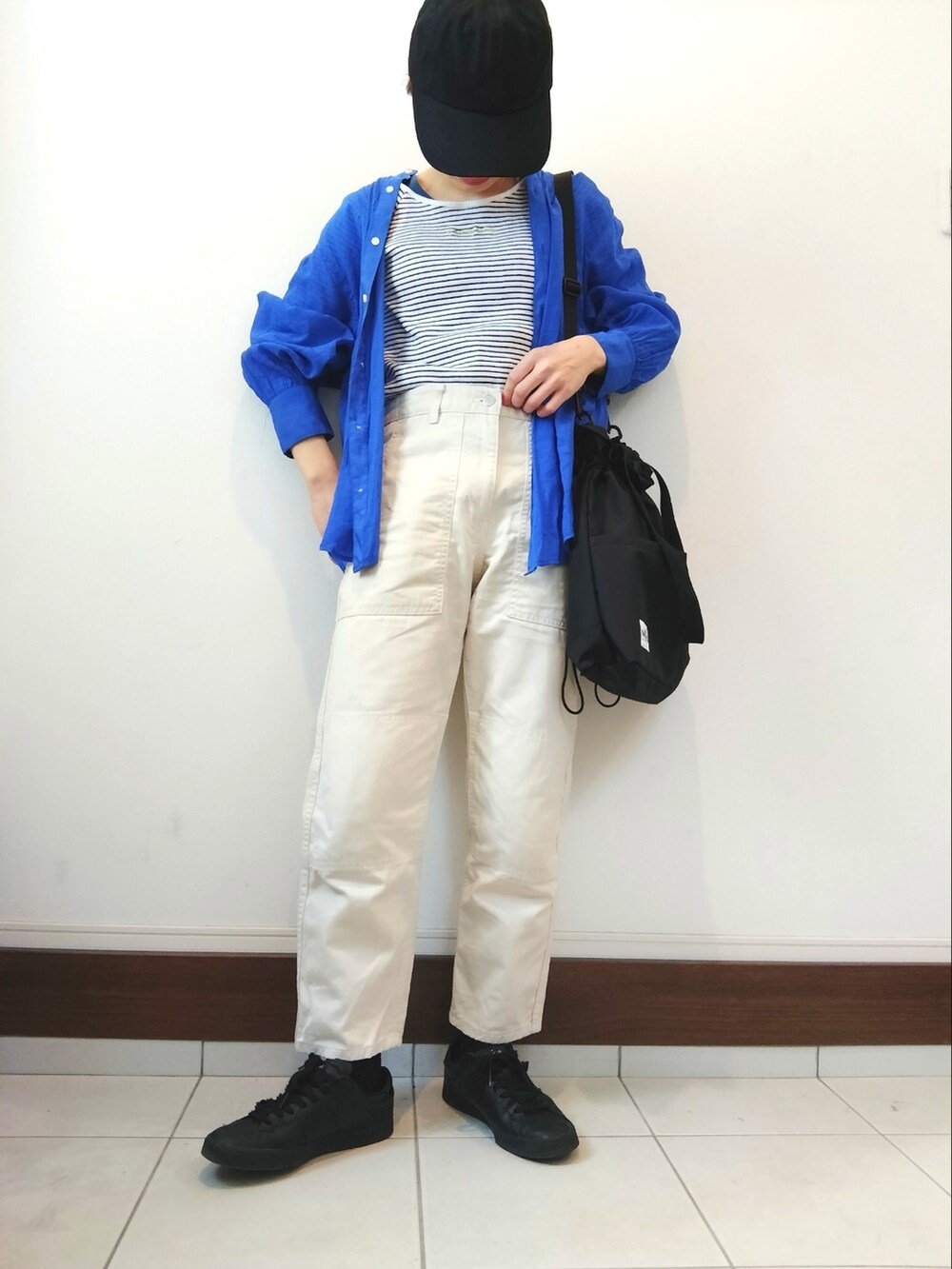 ホワイト系のTシャツ/カットソー、ブラック系のショルダーバッグ、ホワイト系のデニムパンツを着用したレディースの春コーディネートの2枚目の写真