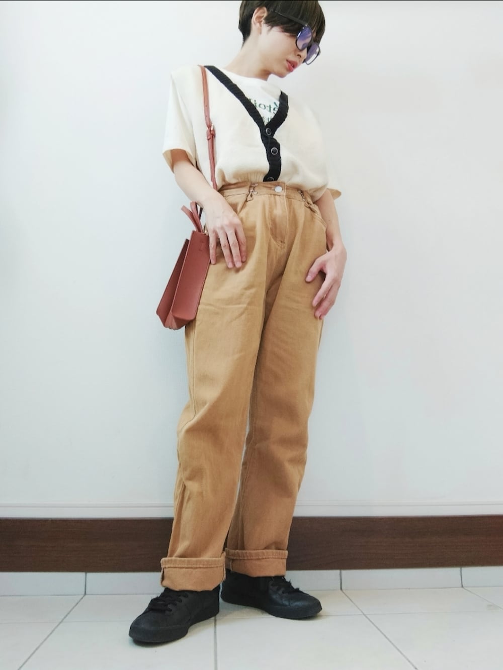 ホワイト系のベスト、ホワイト系のTシャツ/カットソー、ブラウン系のデニムパンツを着用したレディースの秋コーディネートの2枚目の写真