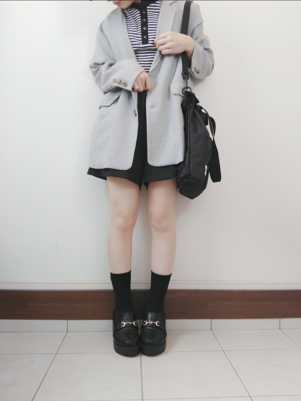 ブラウン系のテーラードジャケット、ブラック系のTシャツ/カットソー、ブラック系のショルダーバッグを着用したレディースの春コーディネートの2枚目の写真