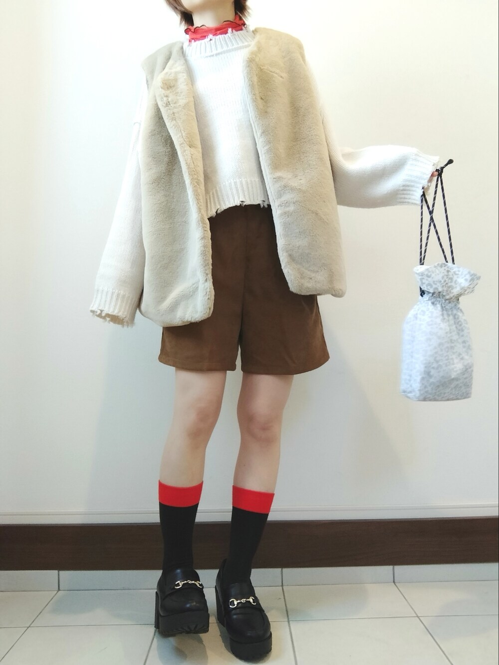 ホワイト系のニット/セーター、イエロー系のその他パンツ、ブラック系のローファーを着用したレディースの冬コーディネートの2枚目の写真