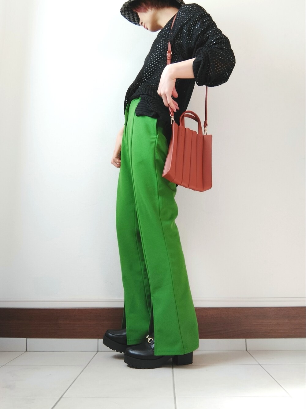グリーン系のその他パンツ、ベージュ系のトートバッグ、ブラック系のニット/セーターを着用したレディースの春コーディネートの2枚目の写真