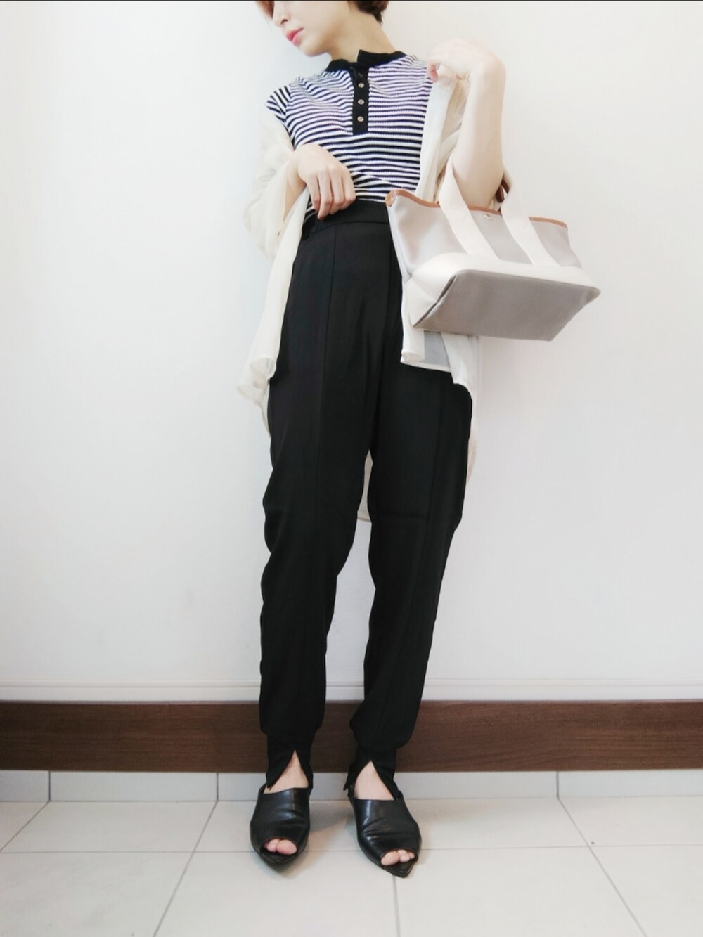 ブラック系のTシャツ/カットソー、グレー系のトートバッグ、ブラック系のその他パンツを着用したレディースの春コーディネートの2枚目の写真