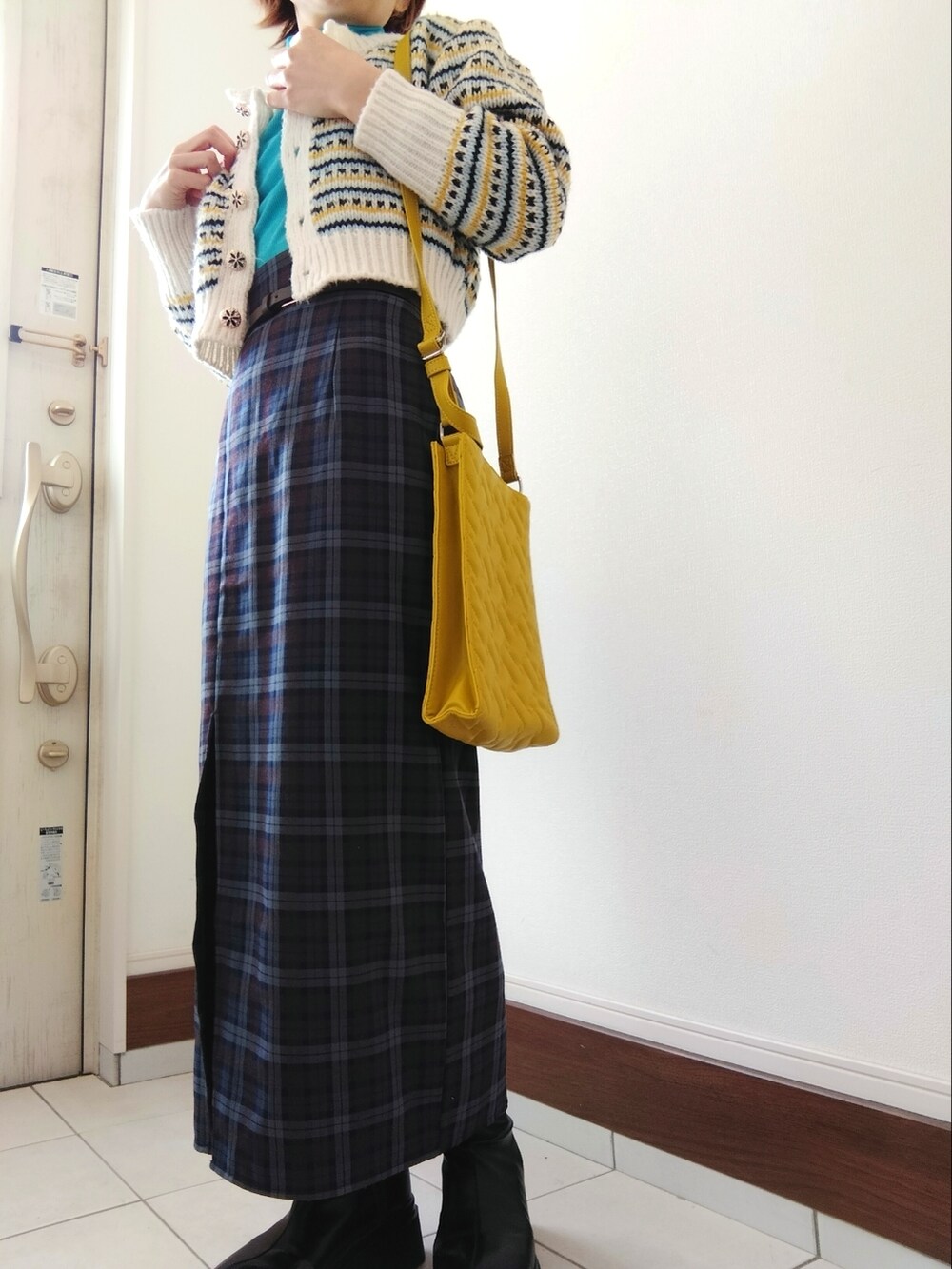 ブルー系のTシャツ/カットソー、ホワイト系のカーディガン/ボレロ、ブルー系のスカートを着用したレディースの冬コーディネートの2枚目の写真