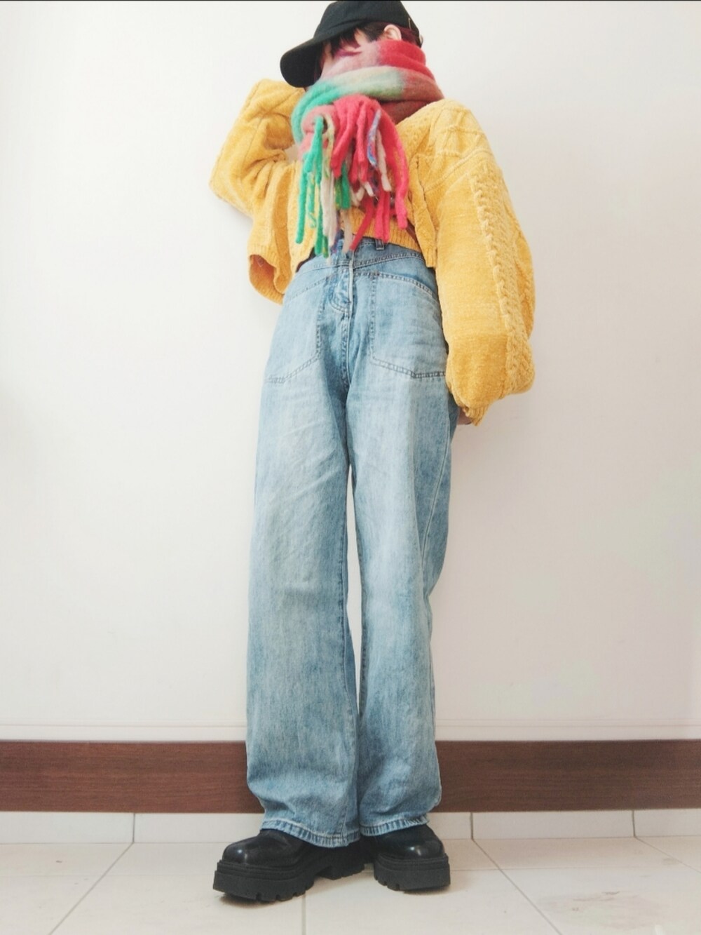 ブラウン系のショルダーバッグ、ブルー系のデニムパンツ、ブラック系のブーツを着用したレディースの冬コーディネートの2枚目の写真