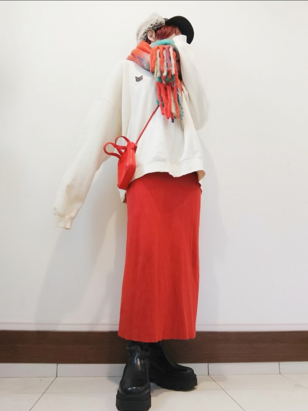 ホワイト系のスウェット、レッド系のショルダーバッグ、レッド系のスカートを着用したレディースの冬コーディネートの2枚目の写真