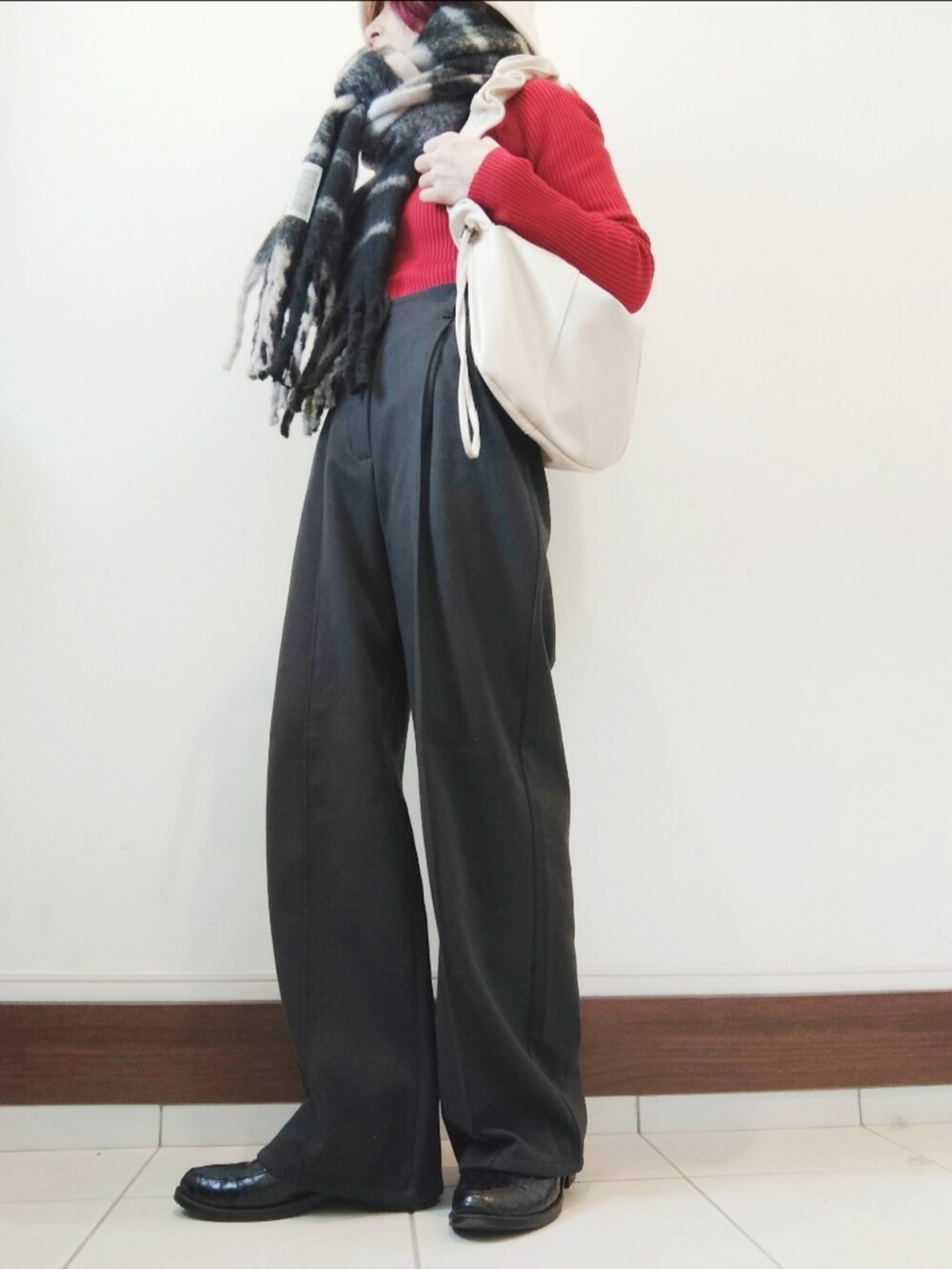 グレー系のその他パンツ、ブラック系のローファー、ホワイト系のショルダーバッグを着用したレディースの冬コーディネートの2枚目の写真