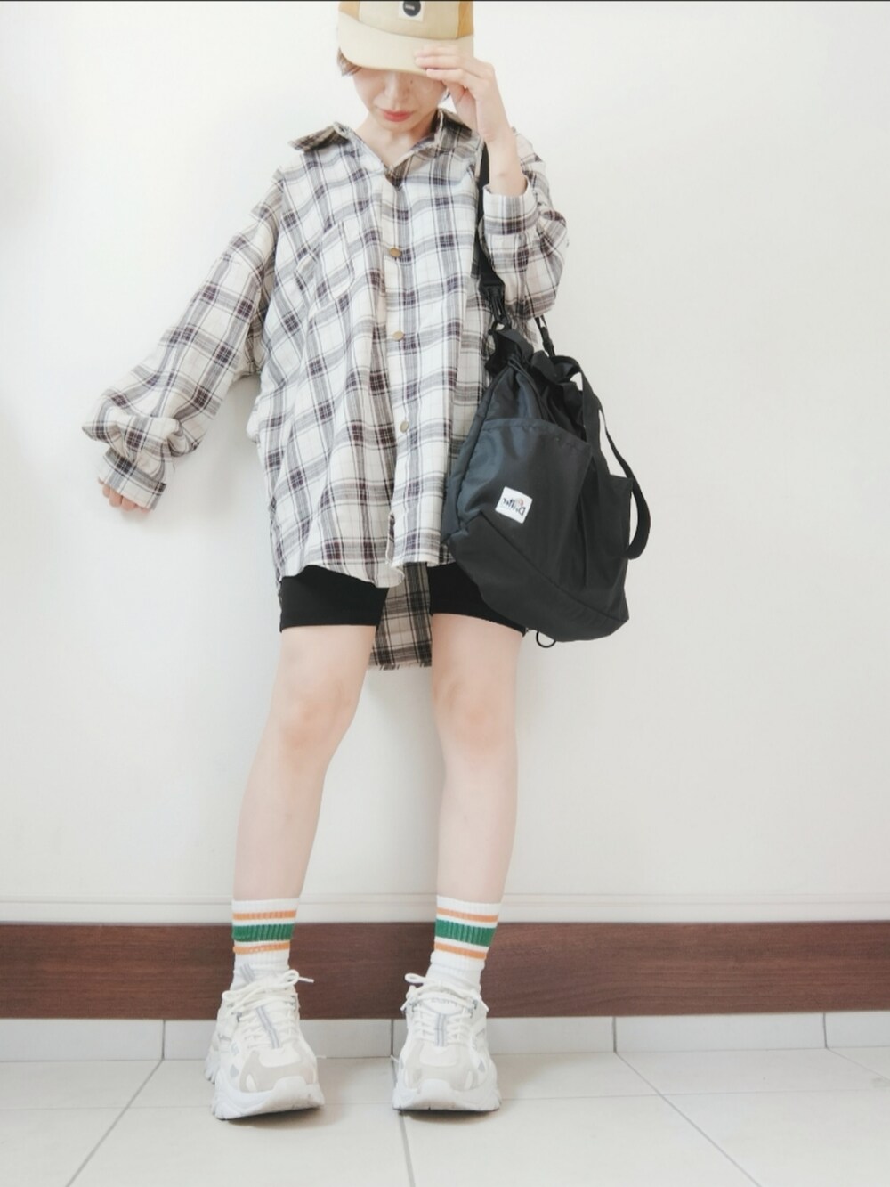 ブラック系のショルダーバッグ、ブラック系のスウェットパンツ、ホワイト系のスニーカーを着用したレディースの秋コーディネートの2枚目の写真