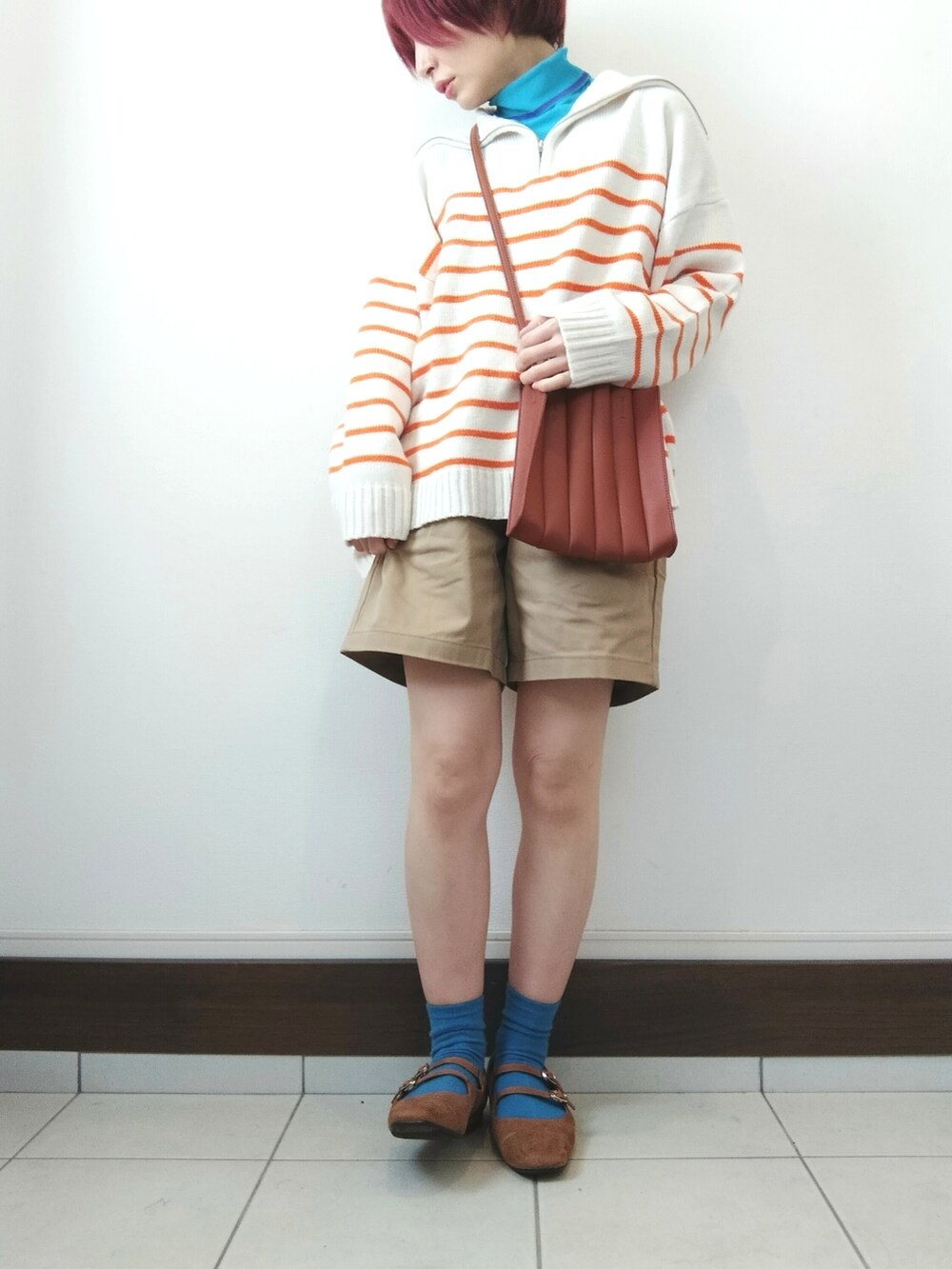 オレンジ系のニット/セーター、ベージュ系のカーゴパンツ、イエロー系のパンプスを着用したレディースの春コーディネートの2枚目の写真