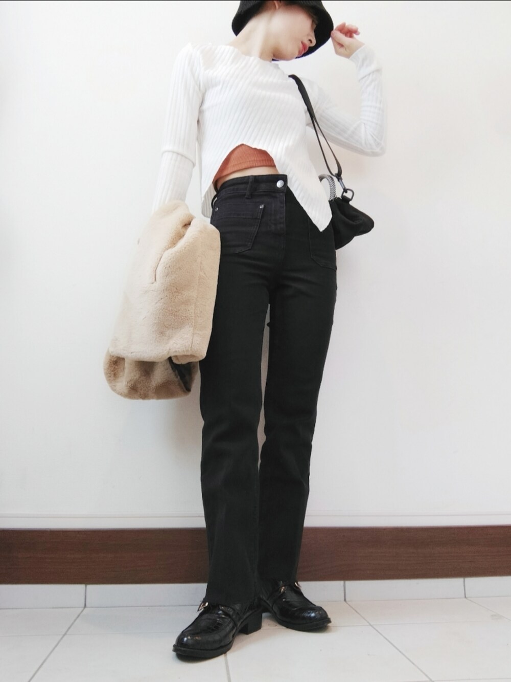 ホワイト系のTシャツ/カットソー、ベージュ系のベスト、ブラック系のデニムパンツを着用したレディースの秋コーディネートの2枚目の写真