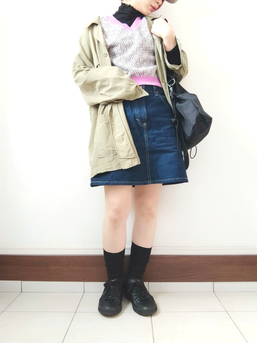 ブルー系のデニムスカート、グレー系のベスト、ブラック系のショルダーバッグを着用したレディースの春コーディネートの2枚目の写真