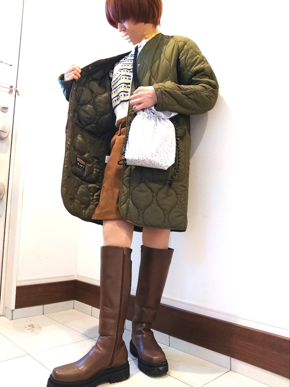 ブラウン系のブーツ、イエロー系のその他パンツ、ホワイト系のカーディガン/ボレロを着用したレディースの冬コーディネートの2枚目の写真