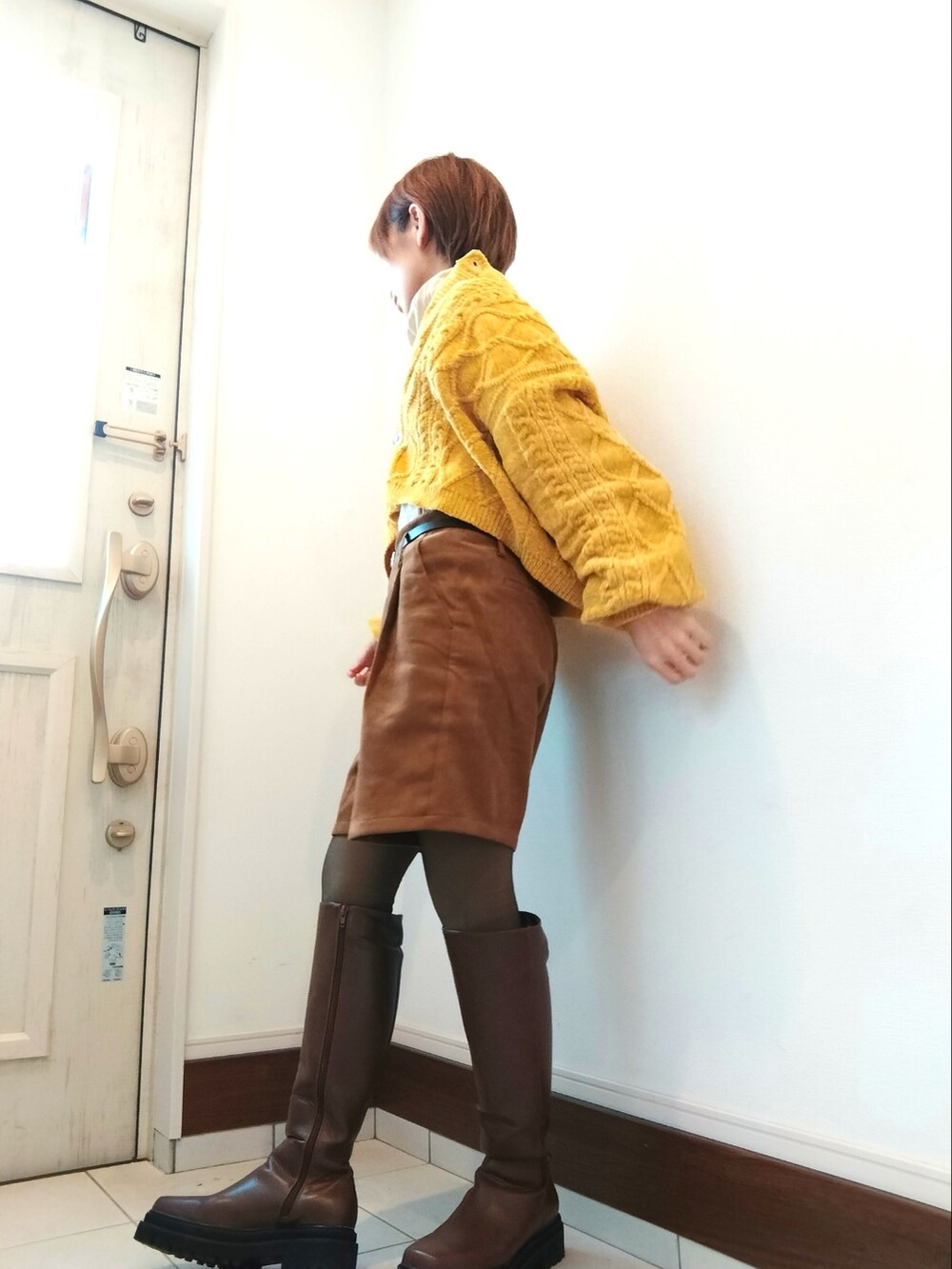 ブラウン系のブーツ、イエロー系のその他パンツ、イエロー系のカーディガン/ボレロを着用したレディースの冬コーディネートの2枚目の写真